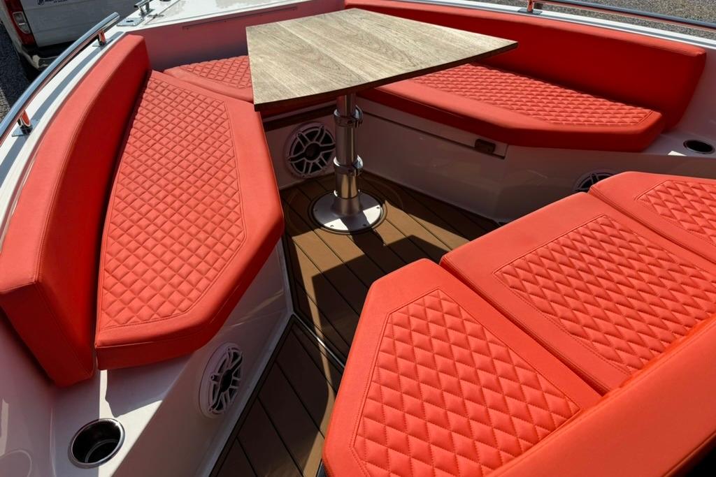 2020 De Antonio Yachts D28 interior with red quilted seating and wooden table.