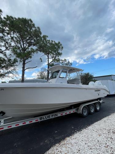 2014 Everglades 325 Center Console boat on trailer, parked outdoors under cloudy sky.
