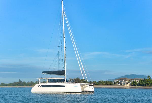 2025 Seawind 1170 catamaran sailing on calm waters near a coastal area.