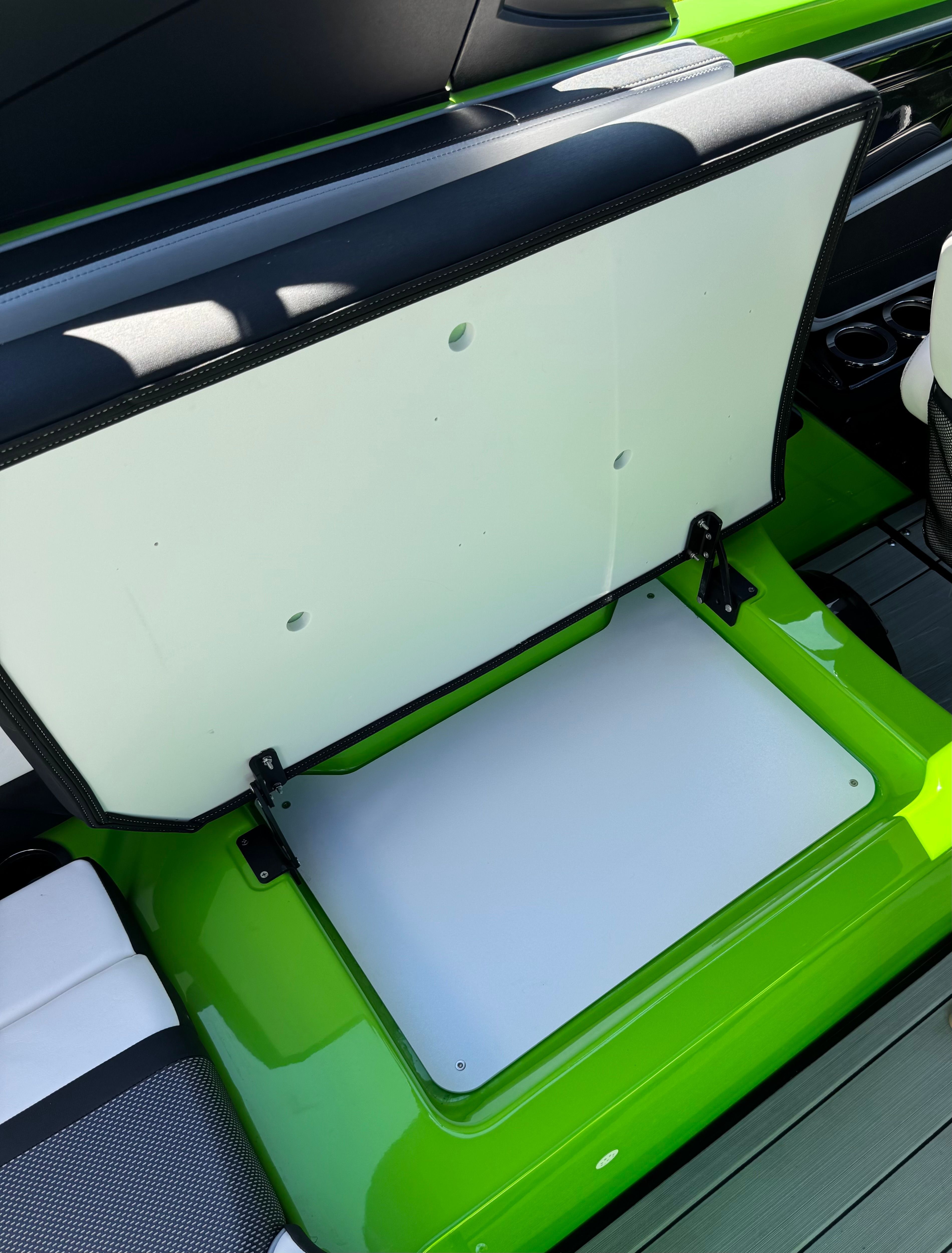 Green seating area with storage on a 2022 Yamaha 255XD boat.