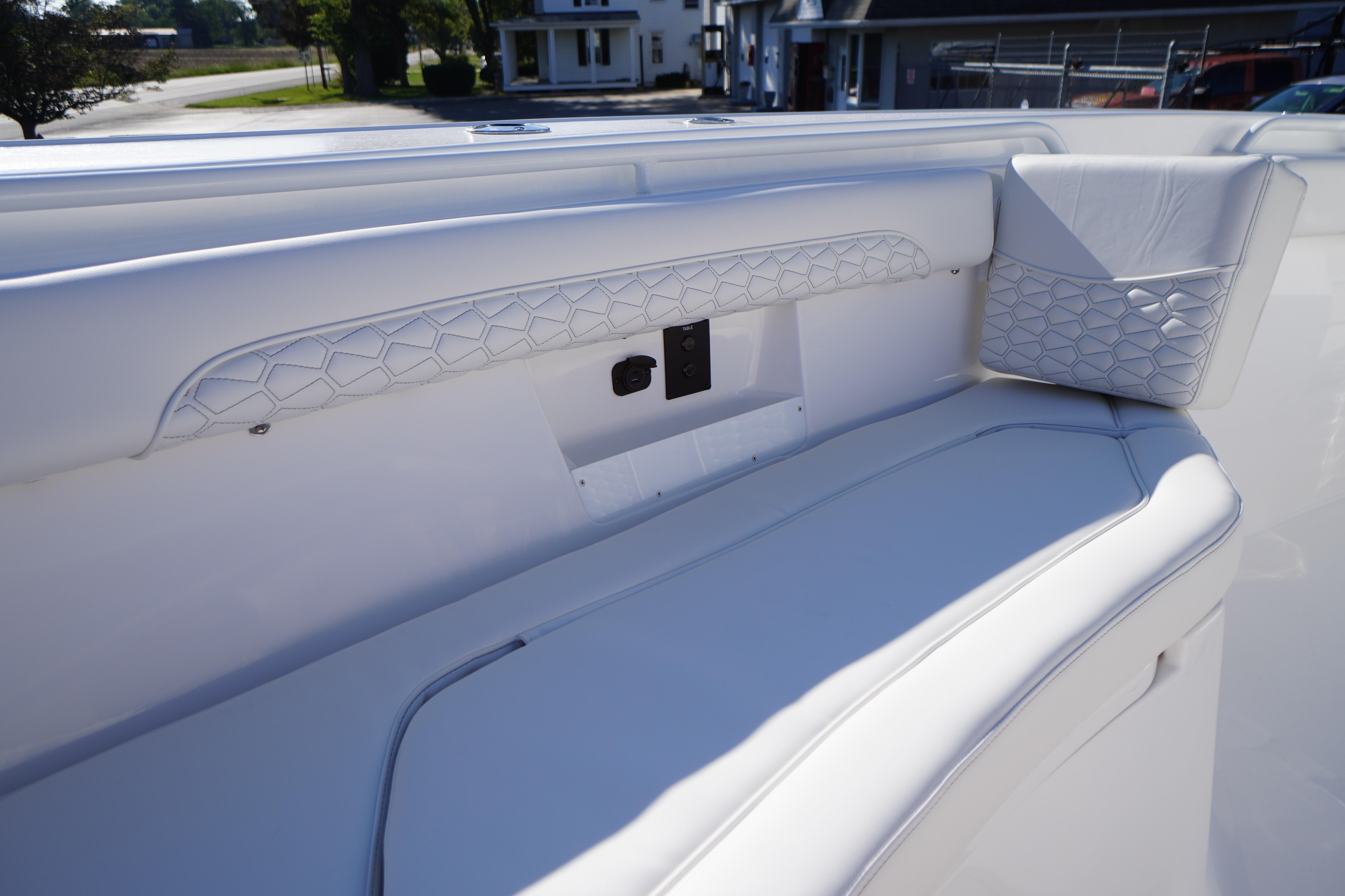 2026 Tidewater 272 LXF boat interior with white cushioned seating and geometric design.