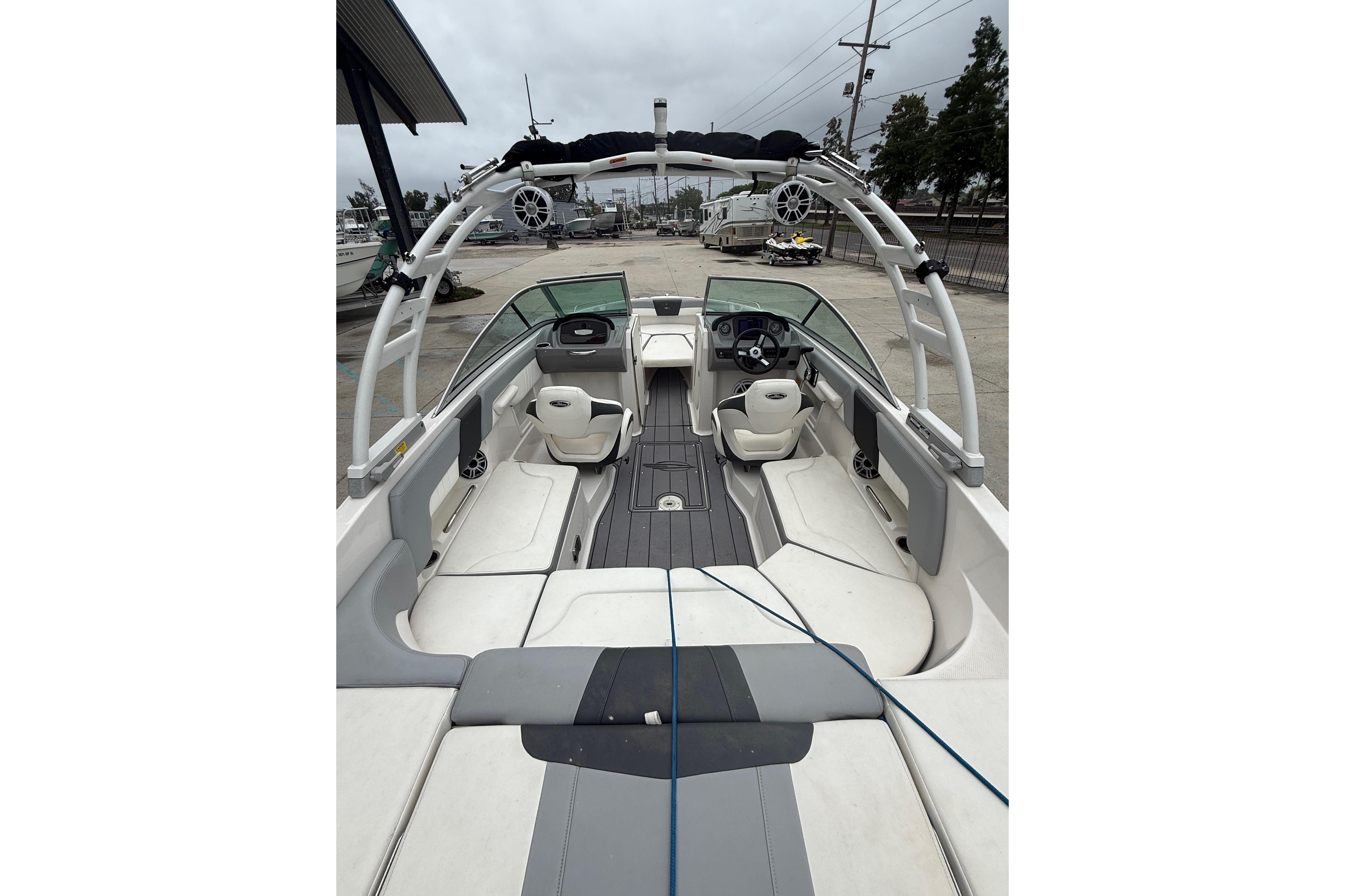 2023 Chaparral 230 SSi boat interior with seating and steering wheel, docked outdoors.