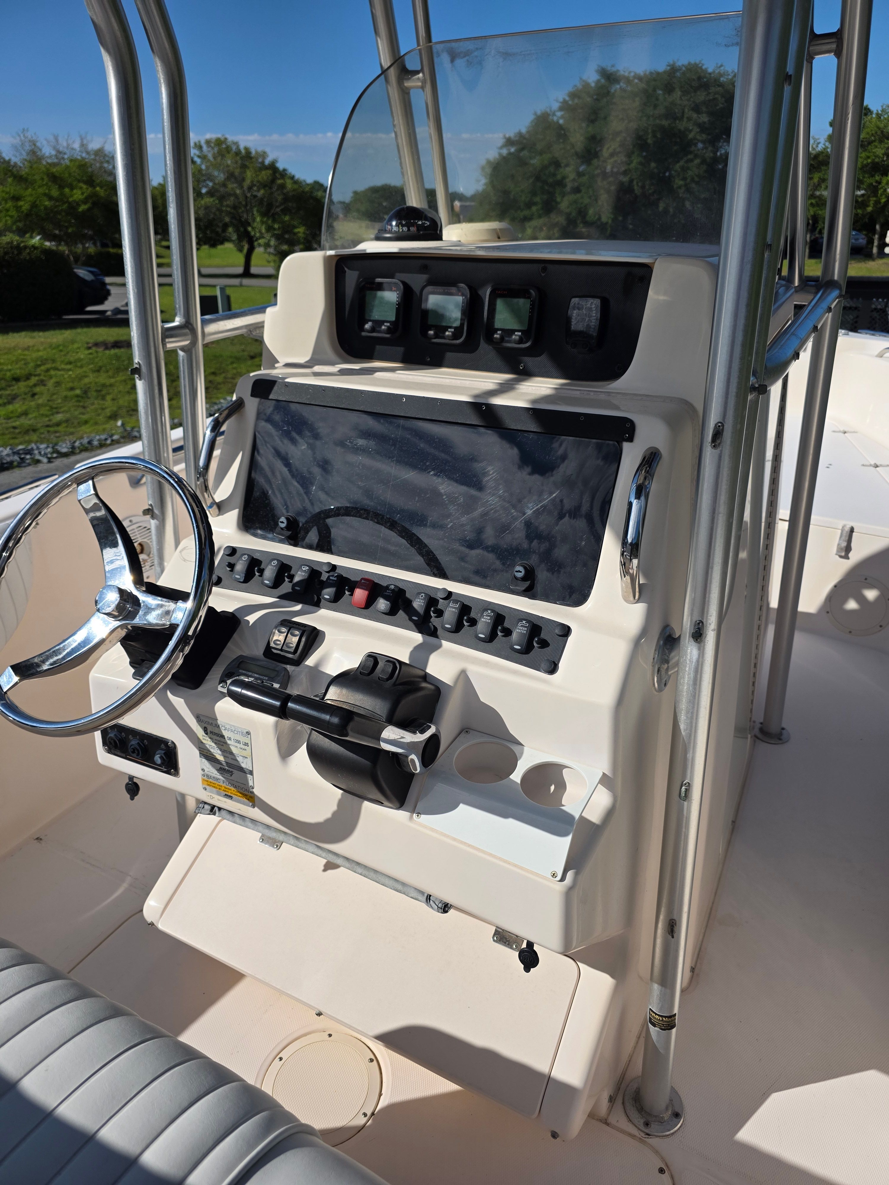 The image shows the helm of a 2006 Grady-White 257 boat with steering wheel and instruments.