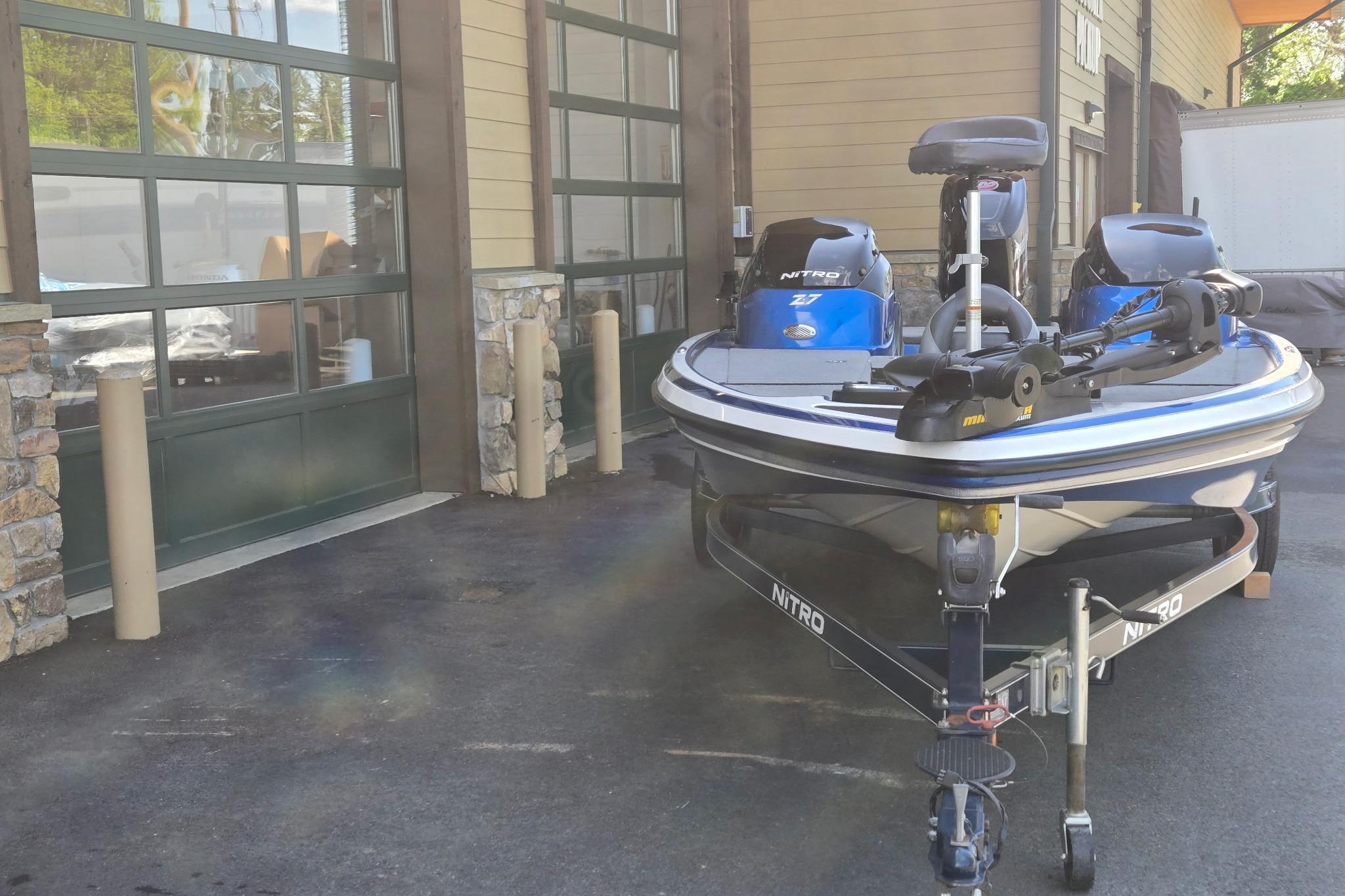 2014 Nitro Z-7 boat parked outside a garage, featuring dual motors.