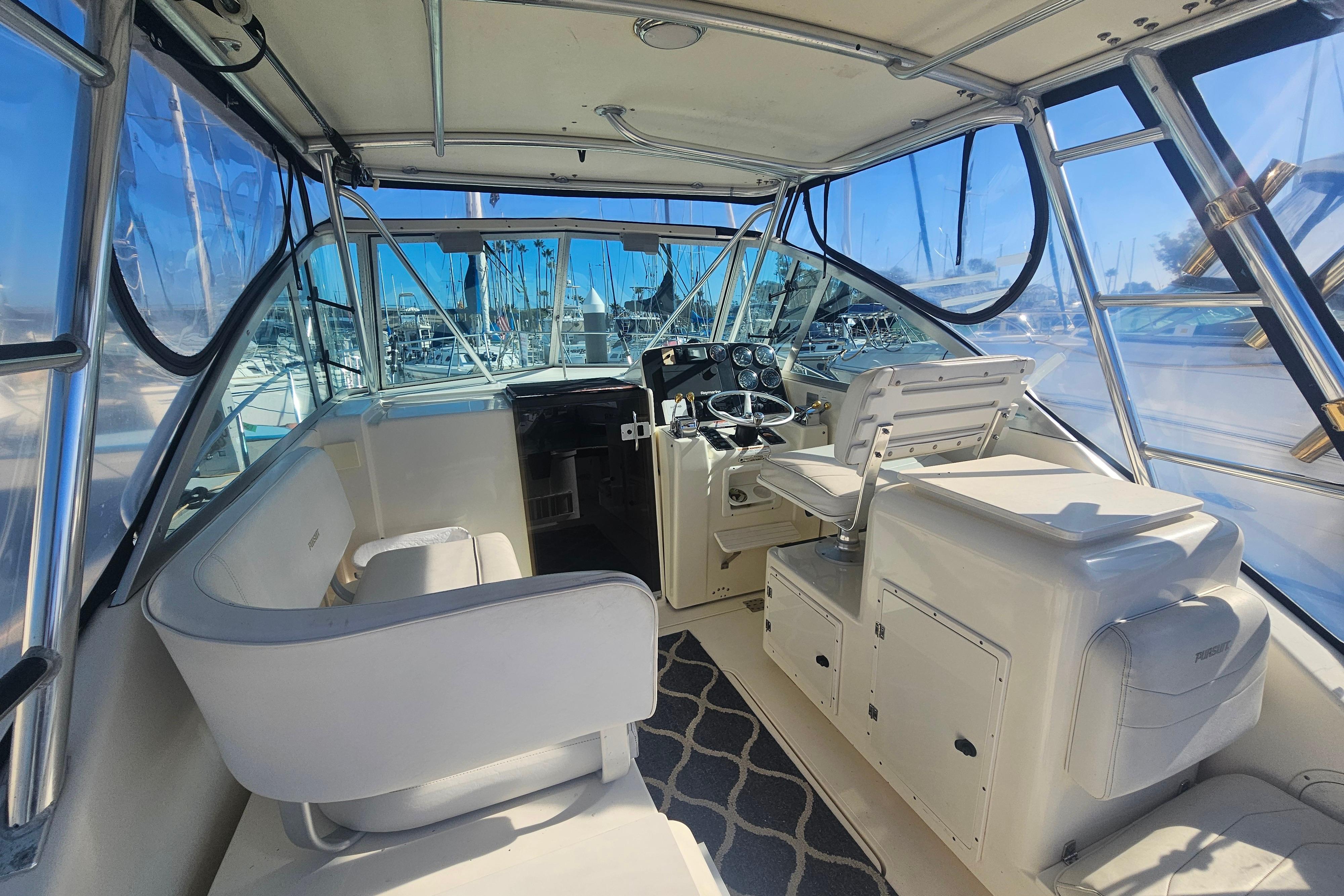 2001 Pursuit 3000 Express boat interior with helm, seating, and clear windows.