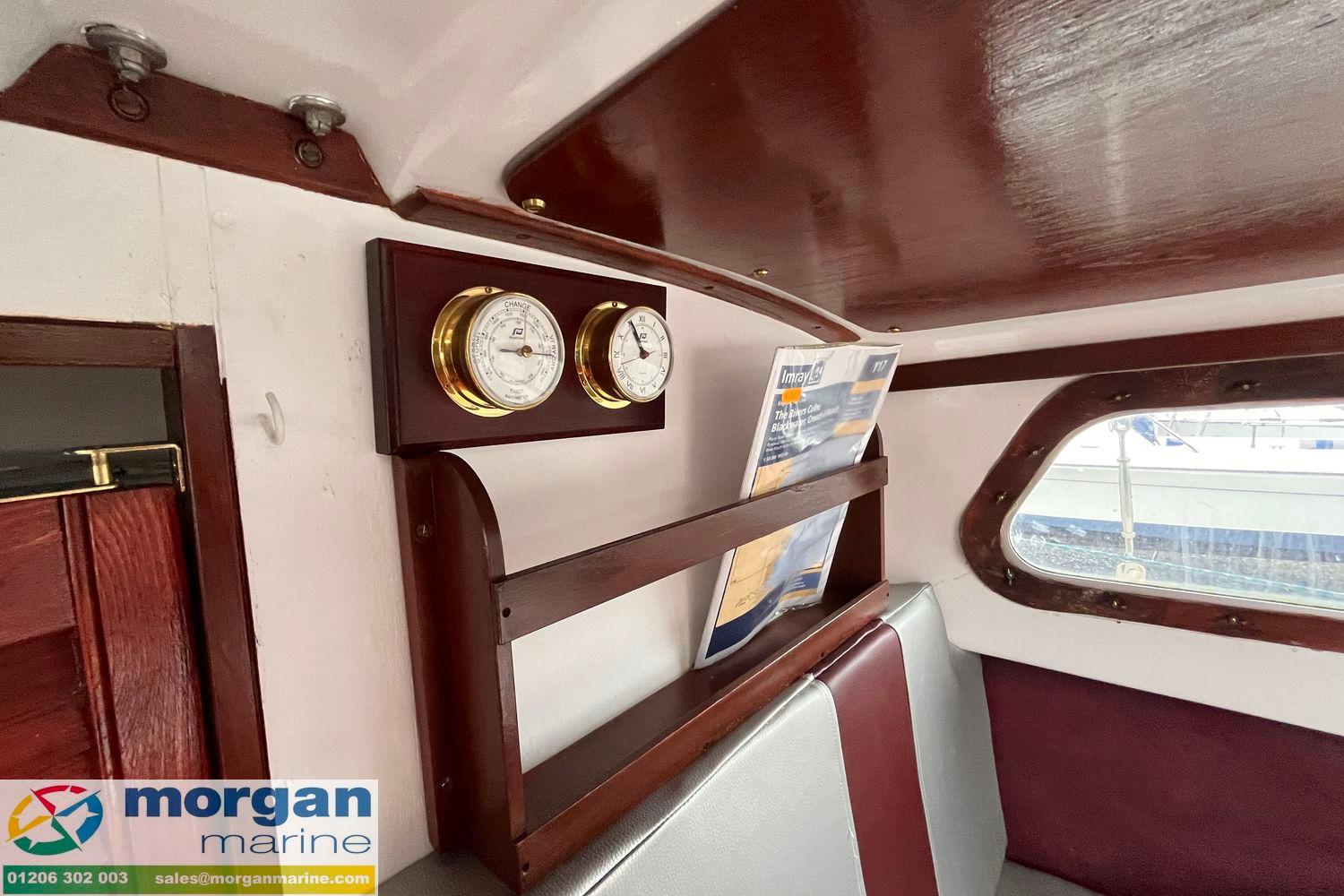 Interior of a 1979 Leisure 23 boat with wooden paneling and nautical instruments.