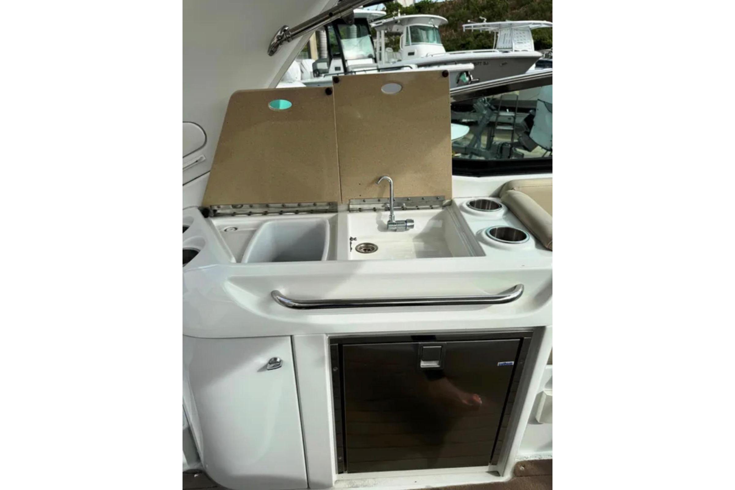 2010 Formula 310 Sun Sport boat kitchenette with sink, faucet, and storage.