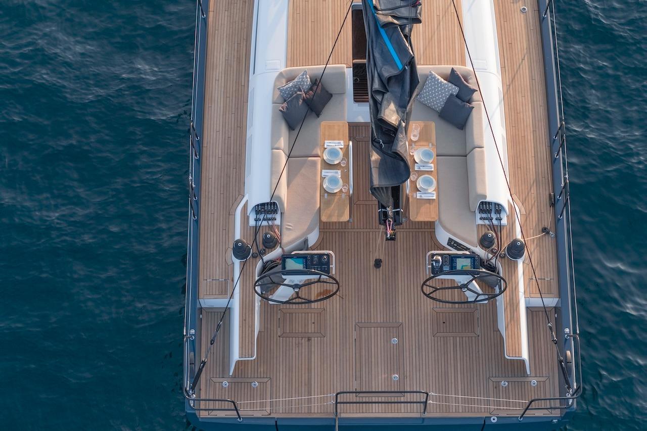 2026 Beneteau First 53 yacht deck with elegant seating and dual steering wheels.