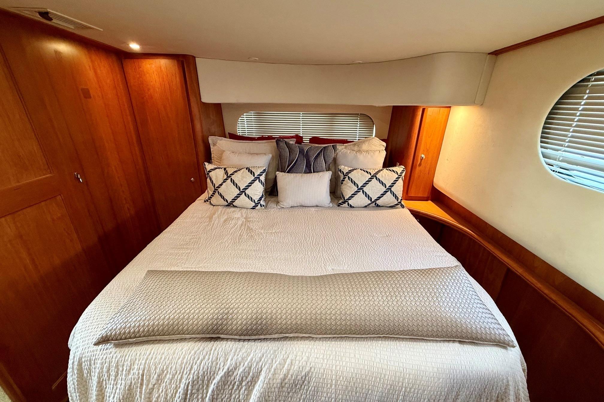 Luxurious bedroom interior of 2004 Silverton 39 Motor Yacht with elegant bedding.