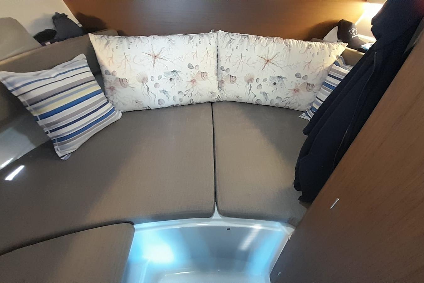 Interior cabin of 2022 Beneteau Antares 8 Fishing boat with cushions and pillows.