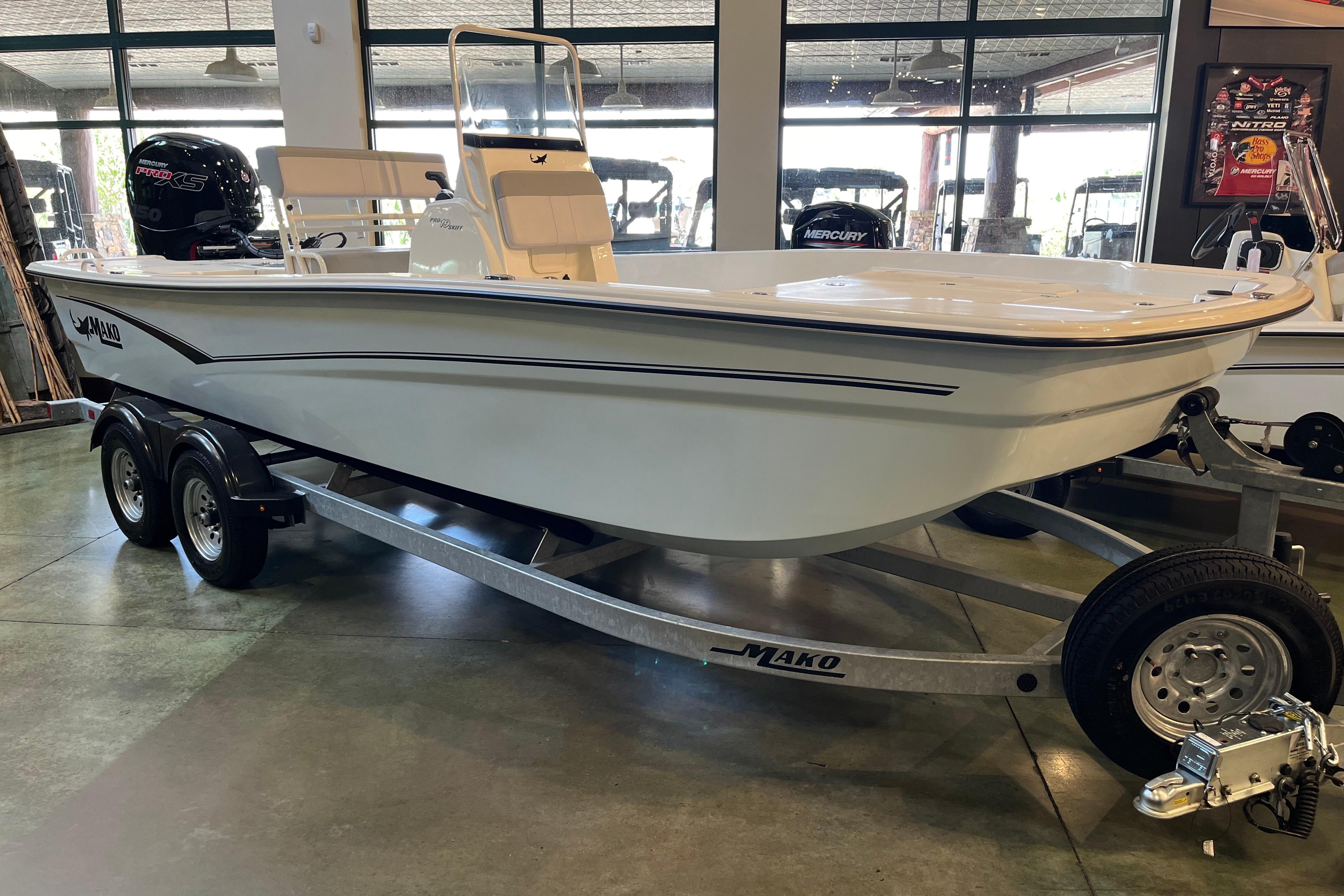 2024 Mako Pro Skiff 19 CC boat on trailer in showroom.