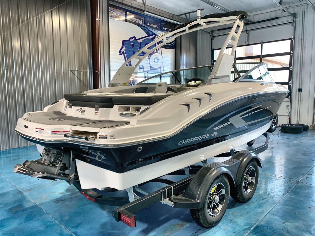2025 Chaparral 21 SSi boat on trailer in showroom, rear view.
