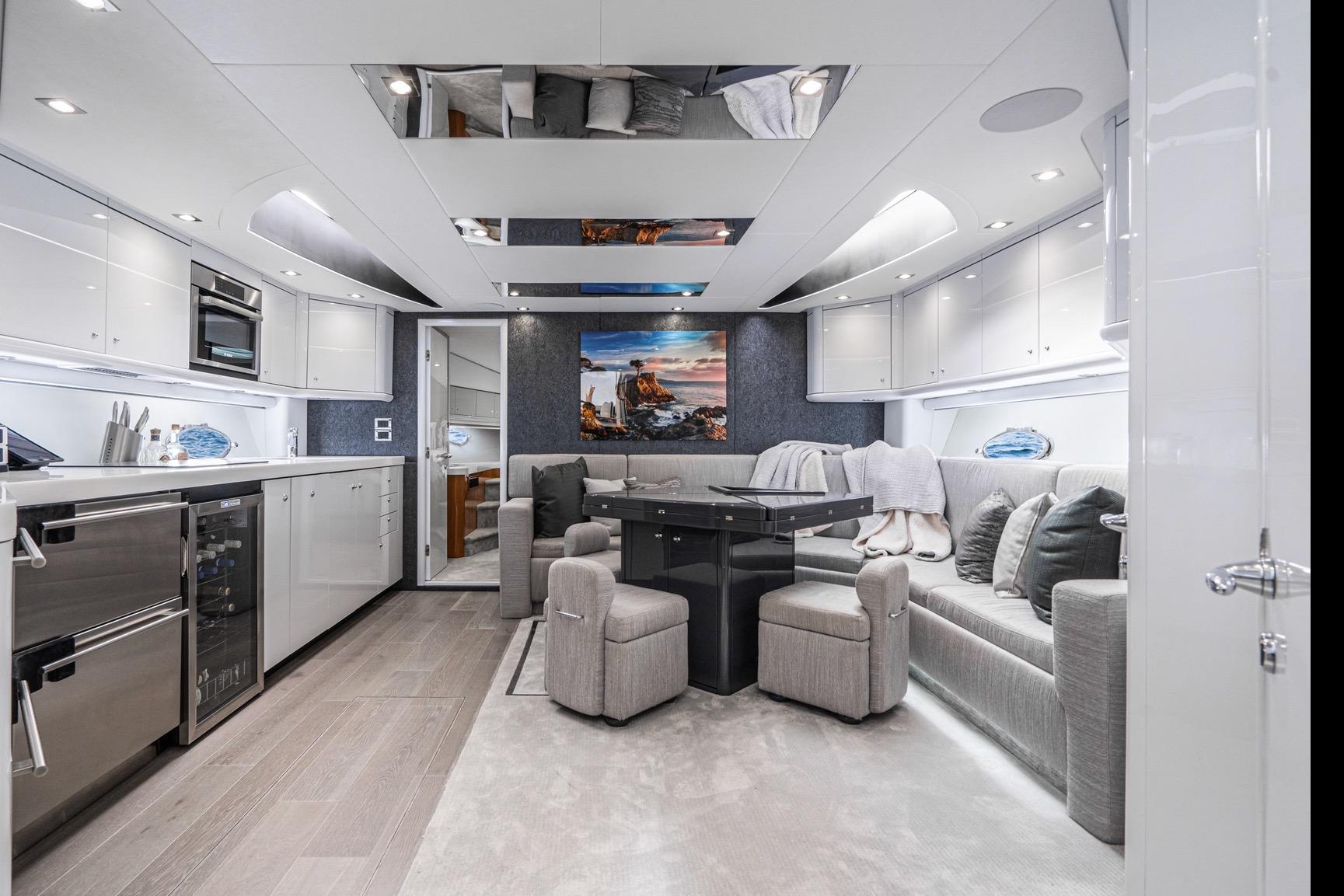 Luxurious interior of 2021 Sunseeker Predator 68 yacht with modern kitchen and seating area.