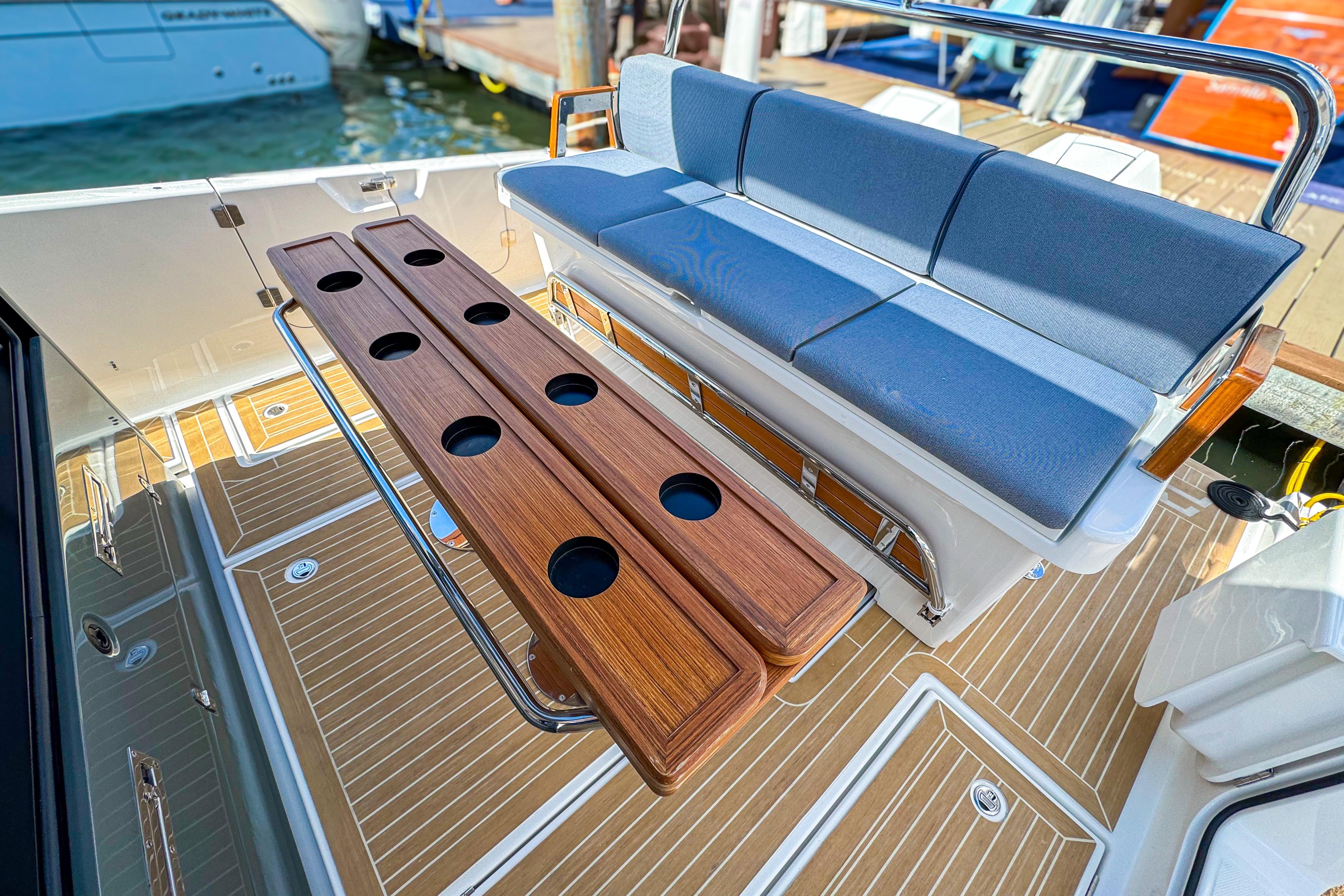 Luxury seating area on 2025 Aiata Wayfinder 38 Cabin yacht with wooden accents and cup holders.