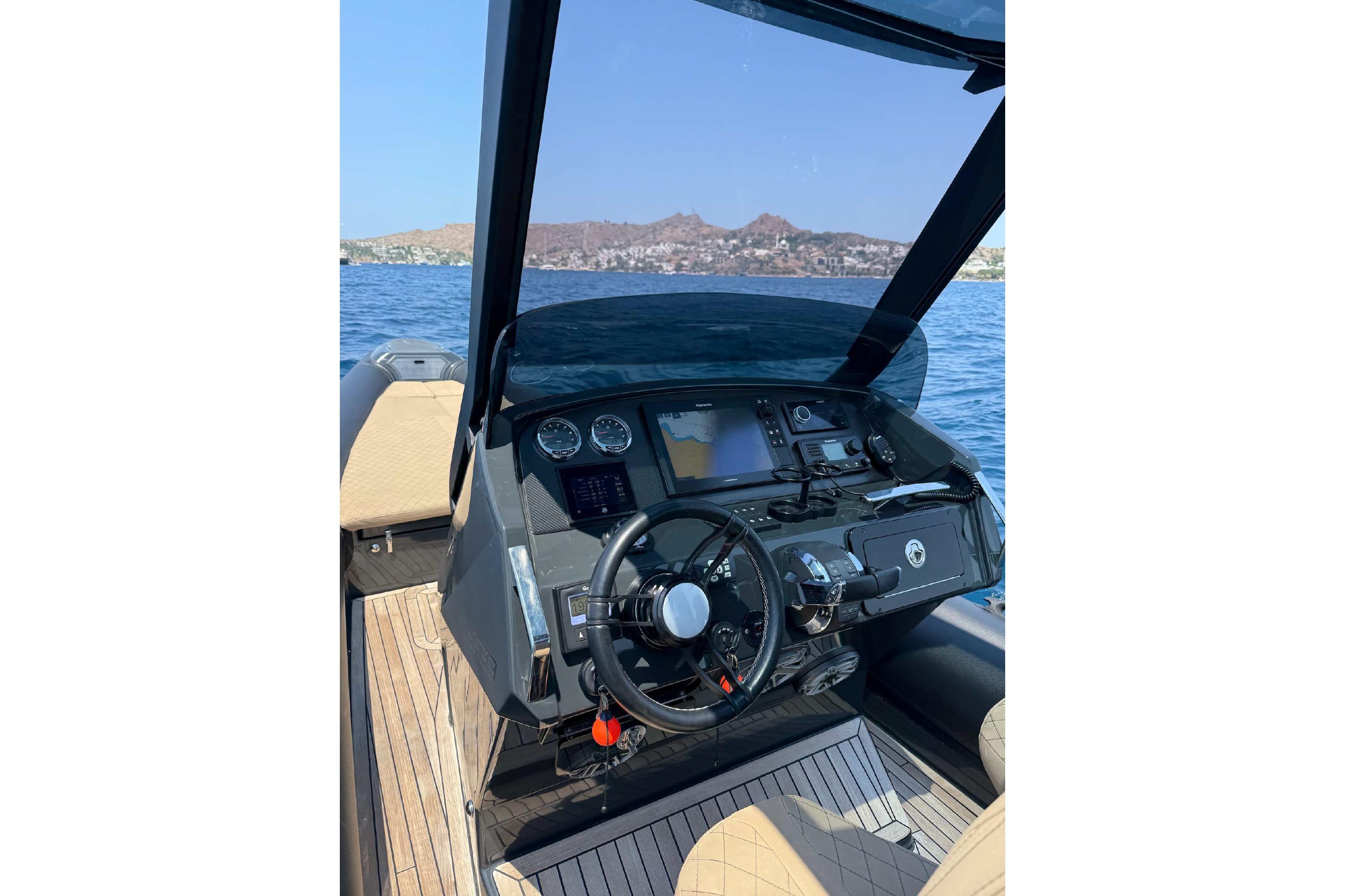 Cockpit of 2021 Ribco Seafarer 33 boat with steering wheel and navigation instruments.