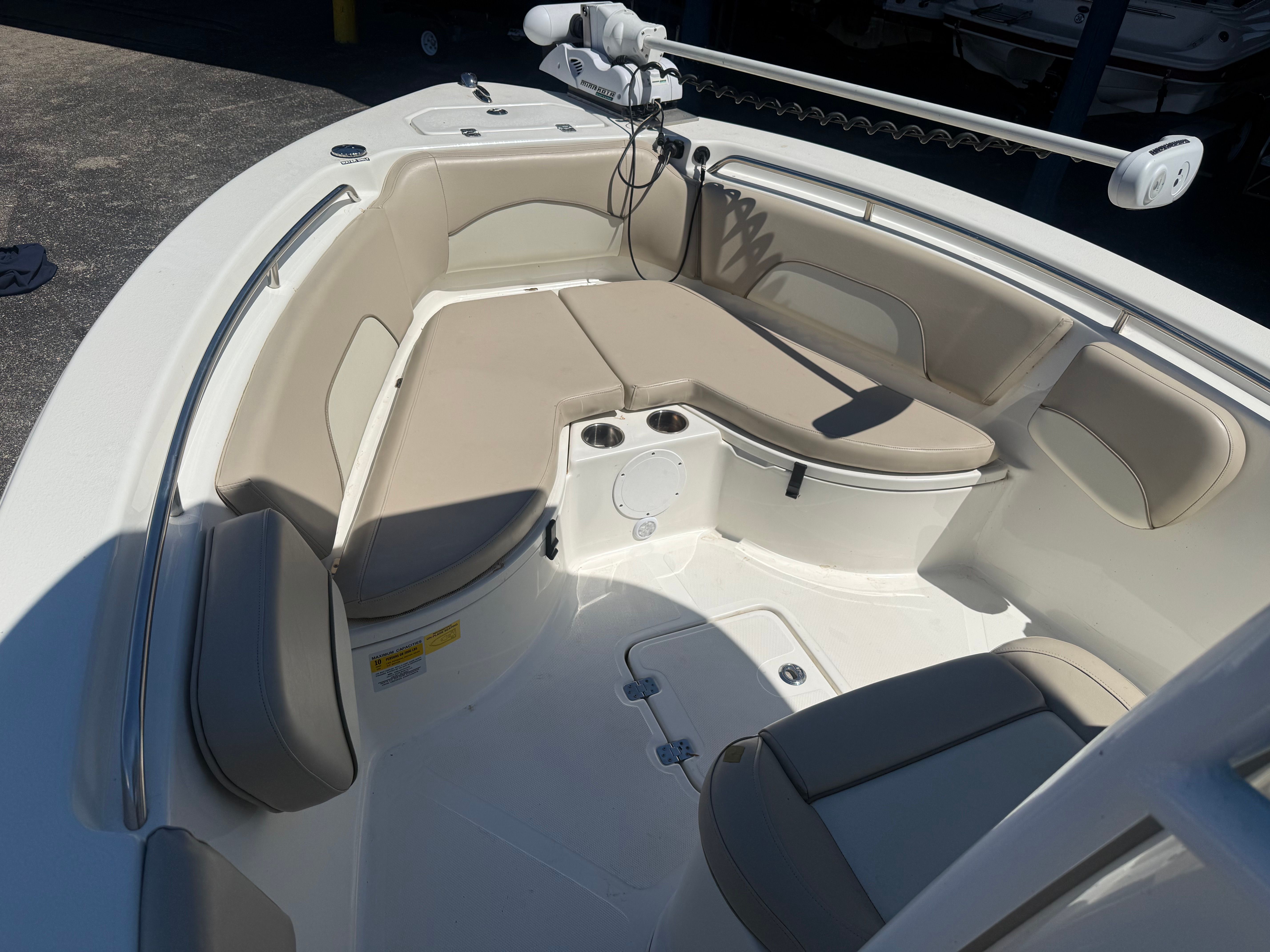 The boat features a spacious seating area with beige cushions and a control unit.