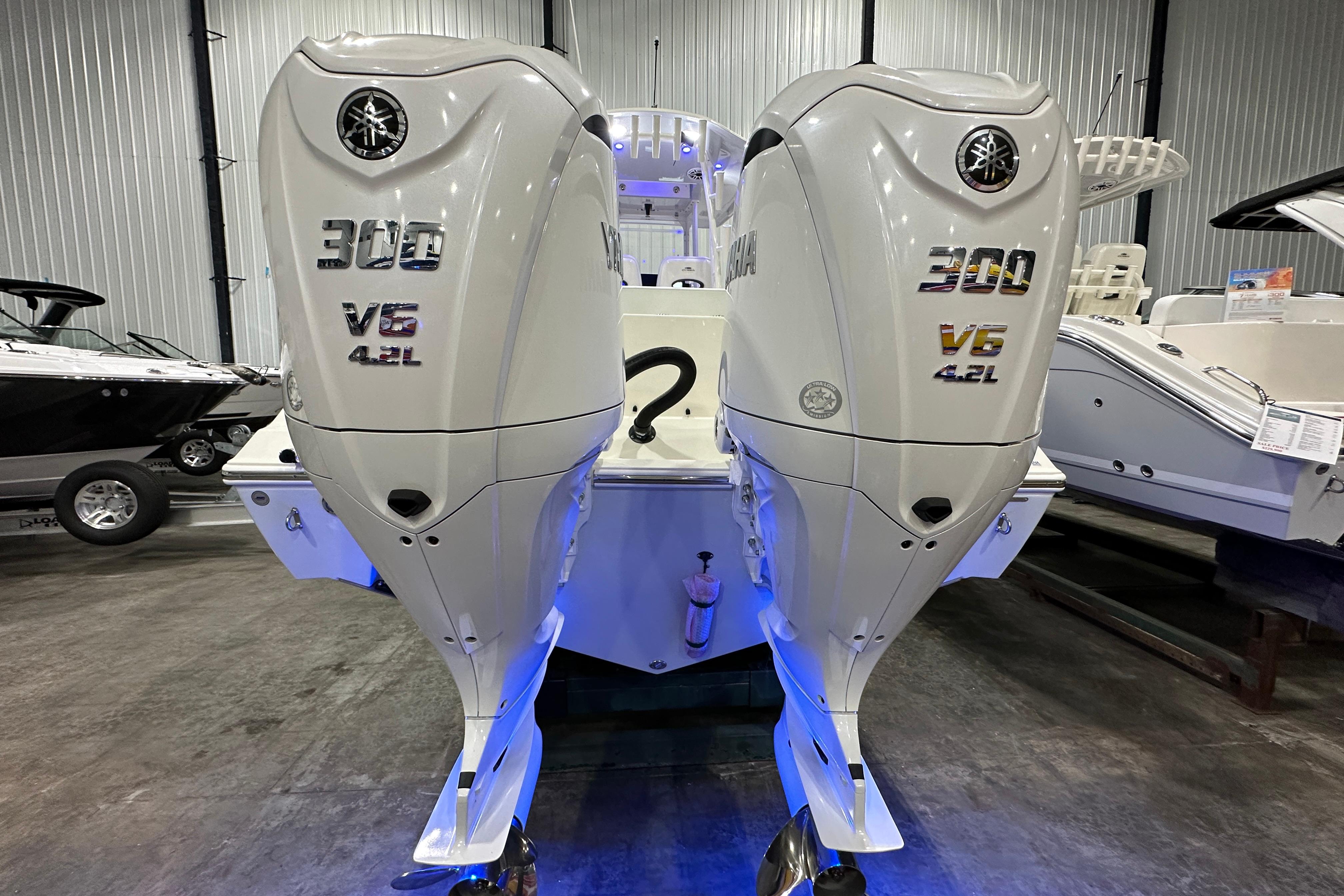 2024 Cobia 301 Center Console with twin Yamaha 300 V6 4.2L engines in a showroom.