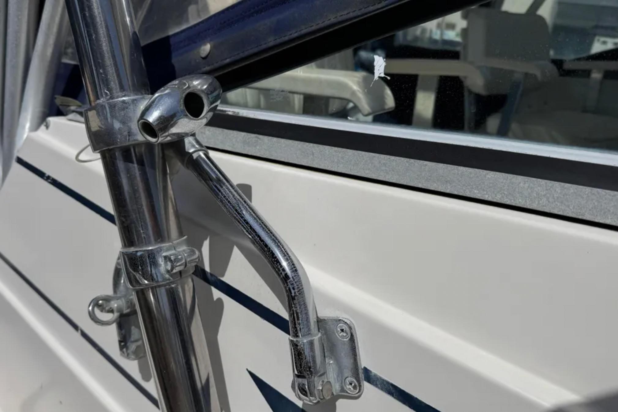 Close-up of a 1990 Grady-White Marlin 280 boat's metal fittings and window detail.