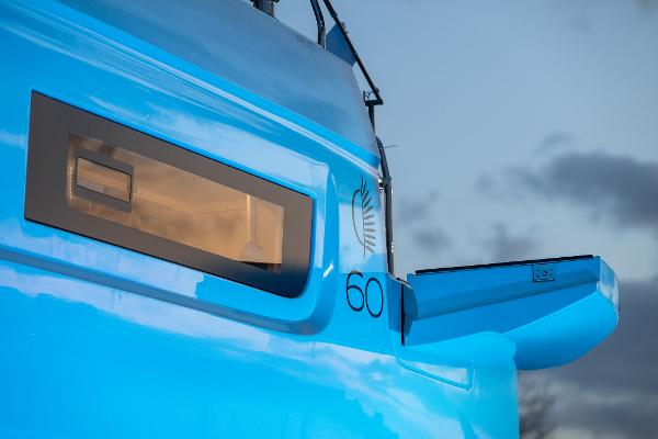 2025 Lagoon 60 yacht, vibrant blue exterior, sleek design, modern window detail.