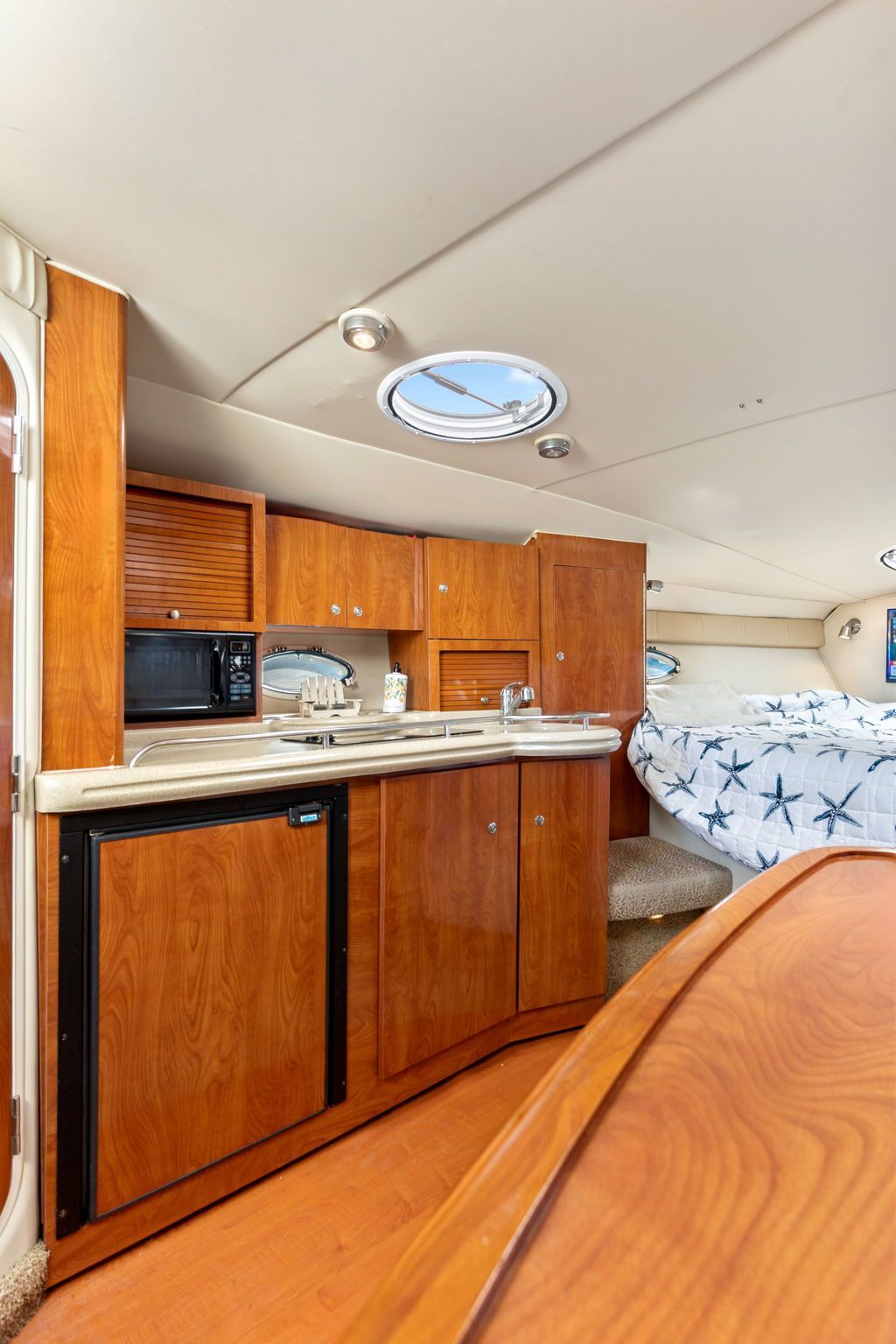 Interior of the 2007 Larson Cabrio 330 featuring a kitchenette and sleeping area.