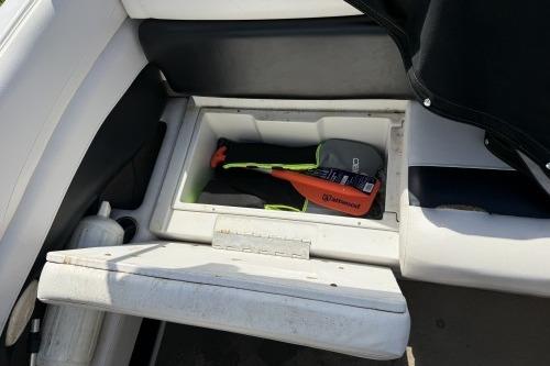 2012 Crownline 215 SS boat storage compartment with safety equipment.
