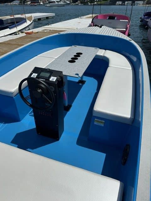 2023 Vision Marine Technologies Volt 180 boat interior with blue and white seating, docked at marina.