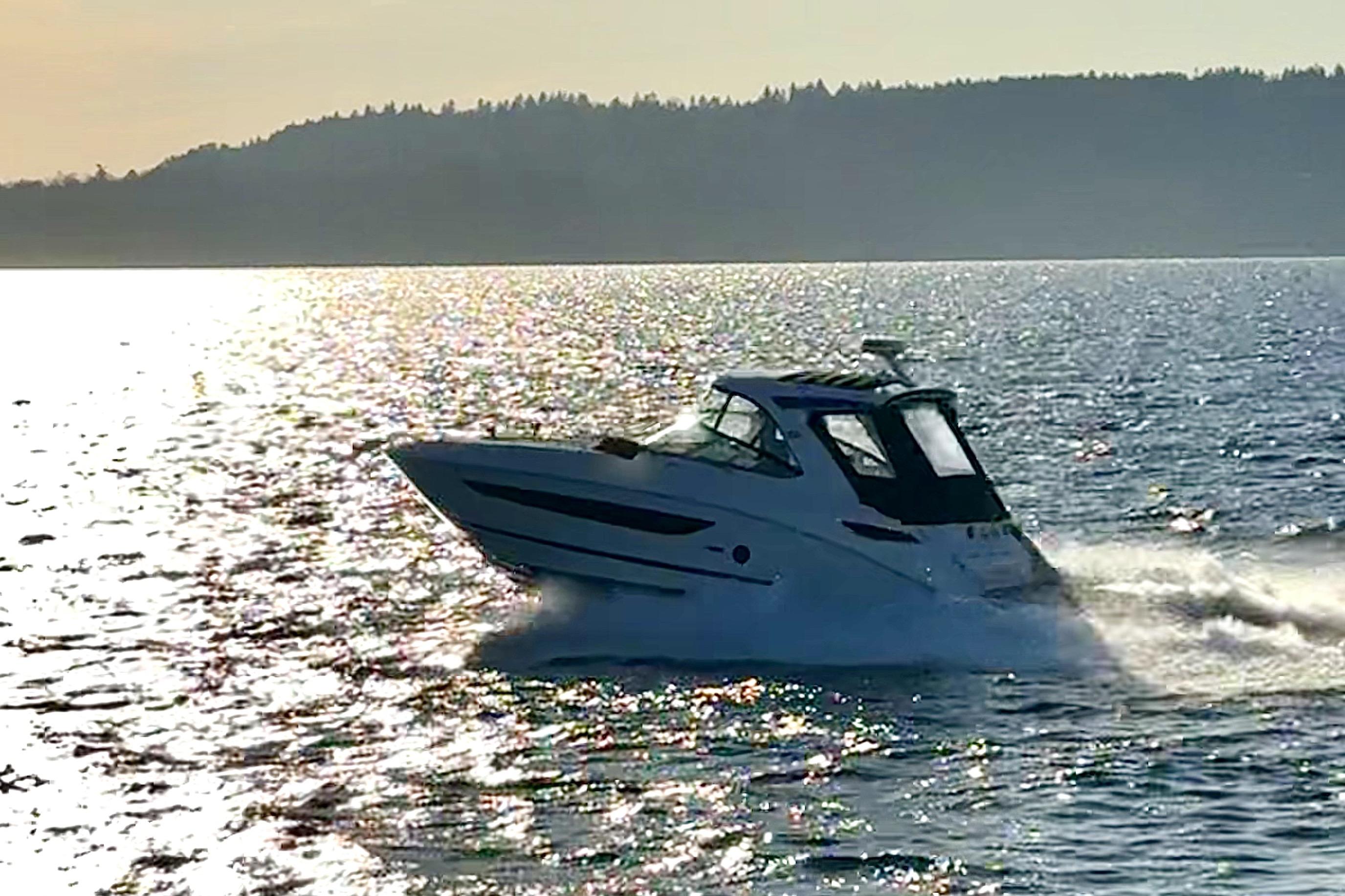 2021 Sea Ray Sundancer 350 cruising on a sunlit lake with scenic background.