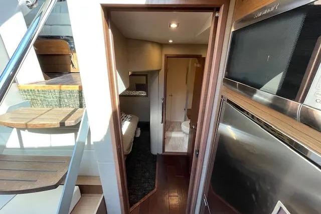 Interior view of 2016 Sea Ray Sundancer 510 yacht, featuring stairs, kitchenette, and cozy cabin.