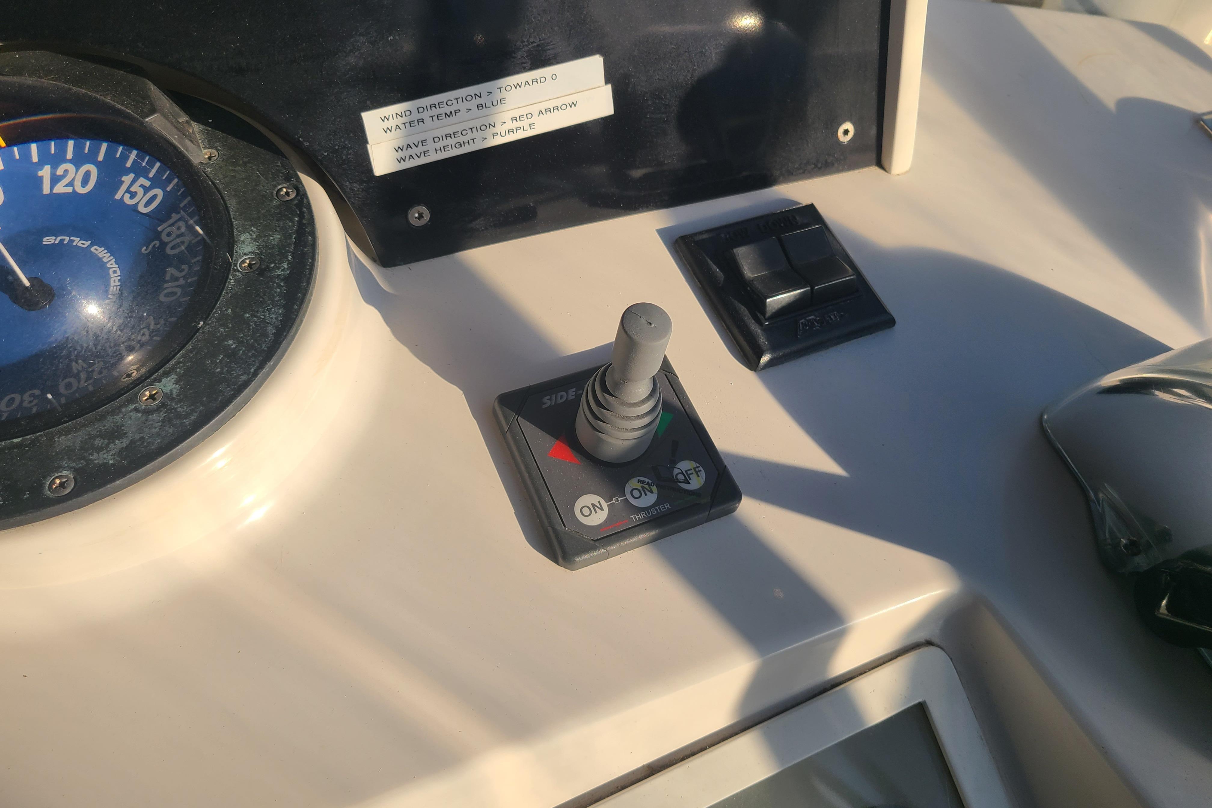 Control panel of a 2000 Grand Banks 46 Classic yacht with joystick and compass.