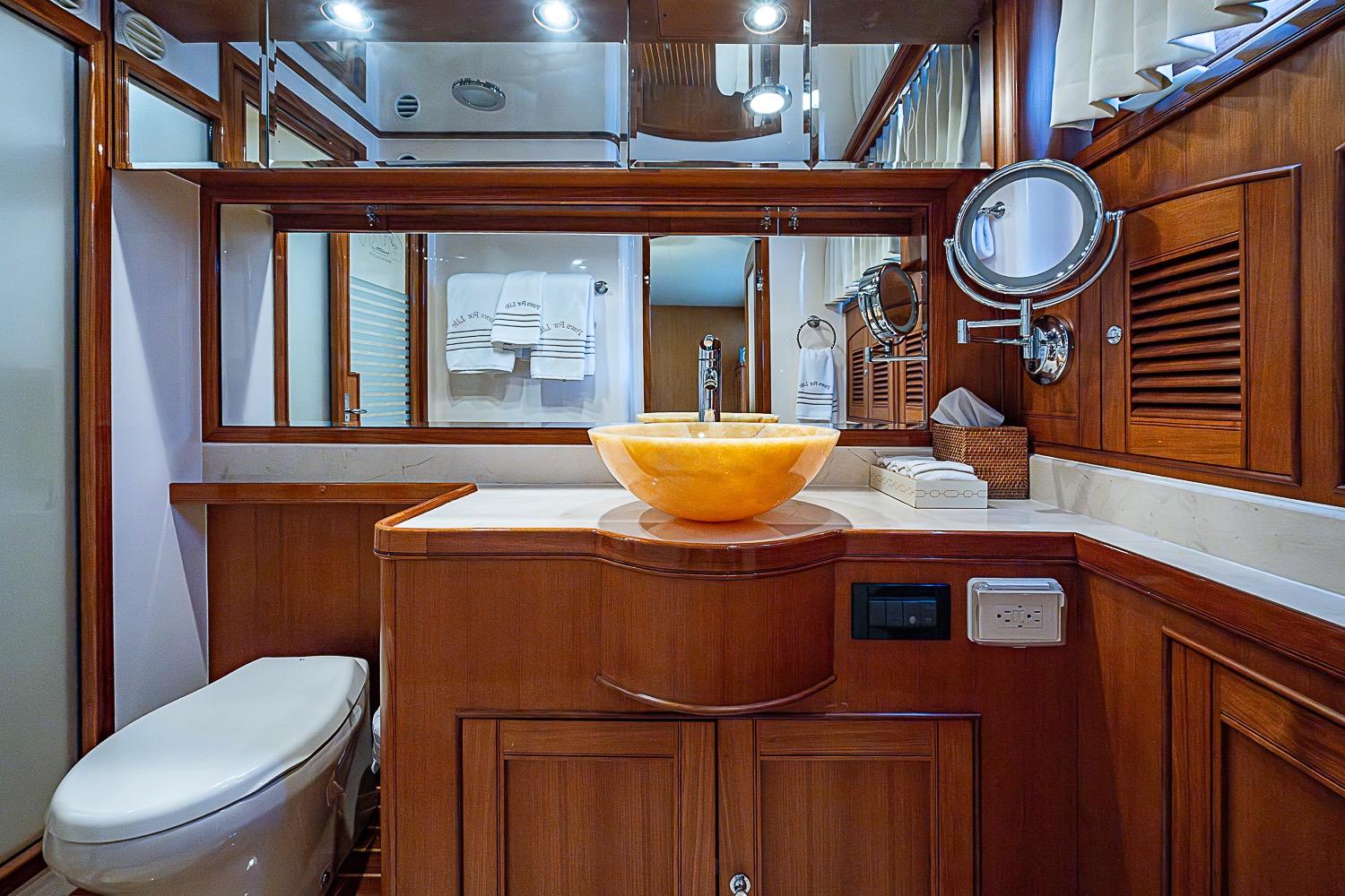 Luxurious bathroom in 2014 Marlow 80 Explorer yacht with elegant wood finishes.