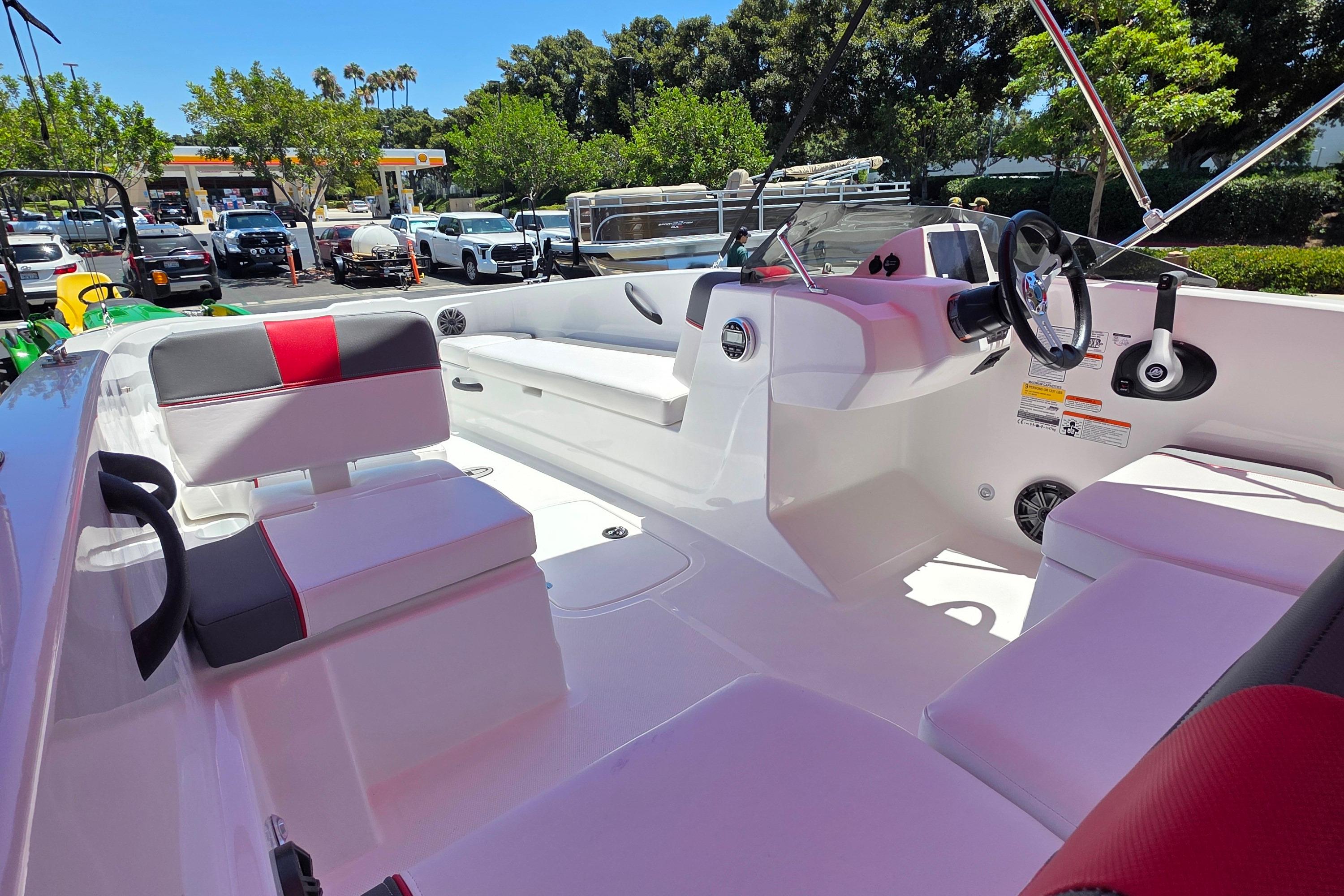 2026 Tahoe T18 boat interior with modern seating and steering, parked outdoors.