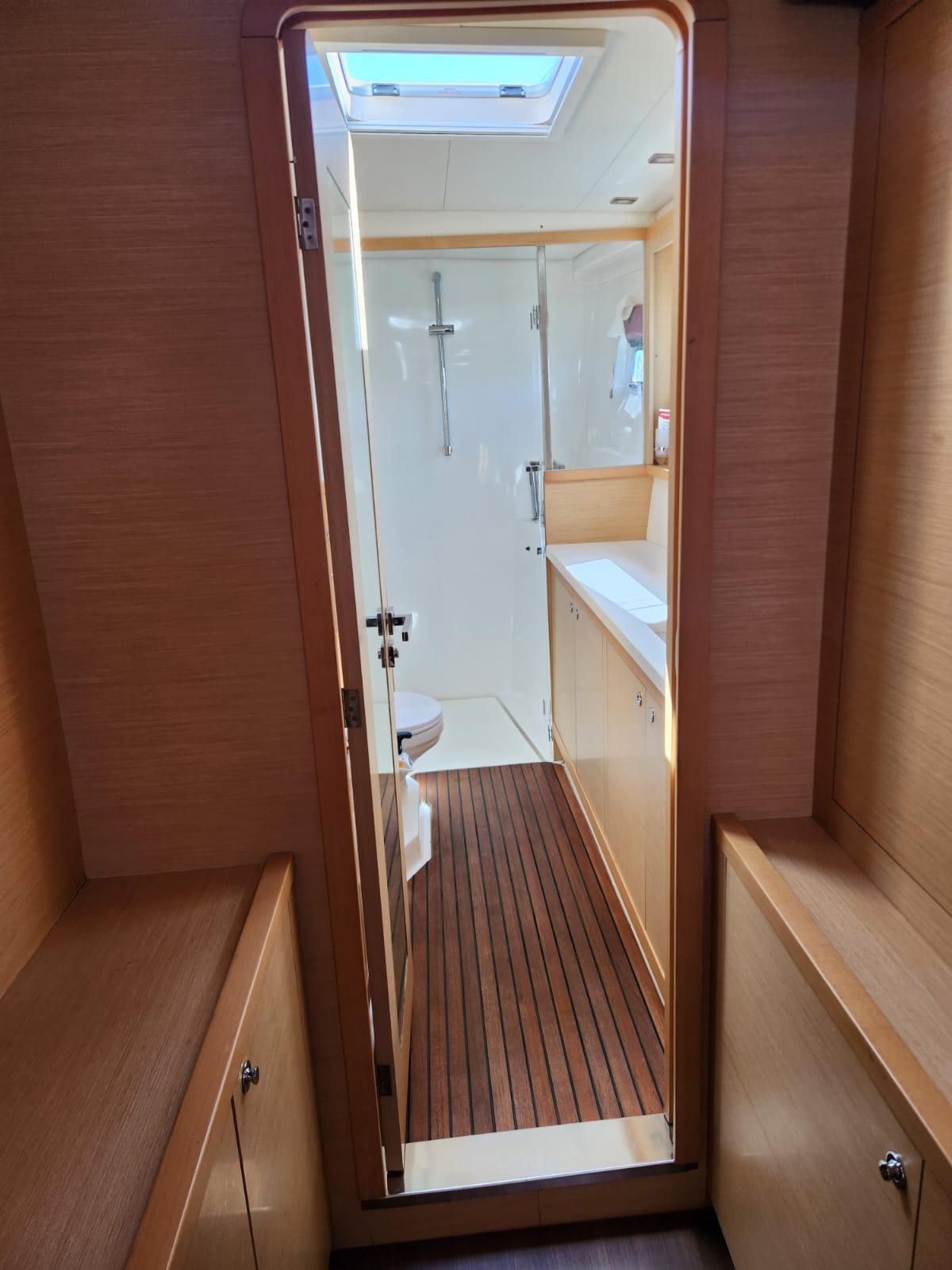 Interior view of 2012 Lagoon 450 F yacht bathroom with wooden flooring and skylight.