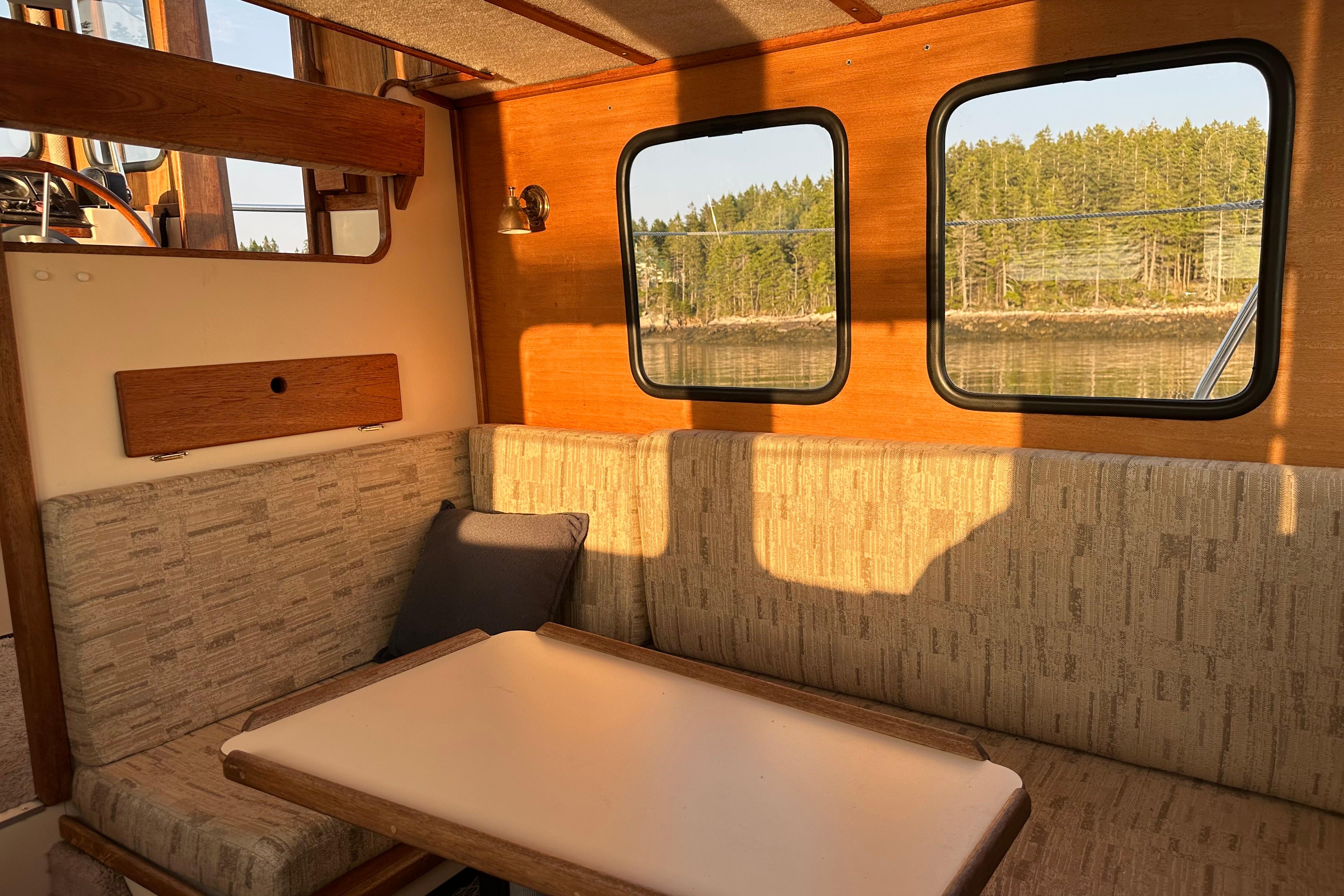 Cozy interior of a 1985 Nordic Tug 26 with scenic window view.