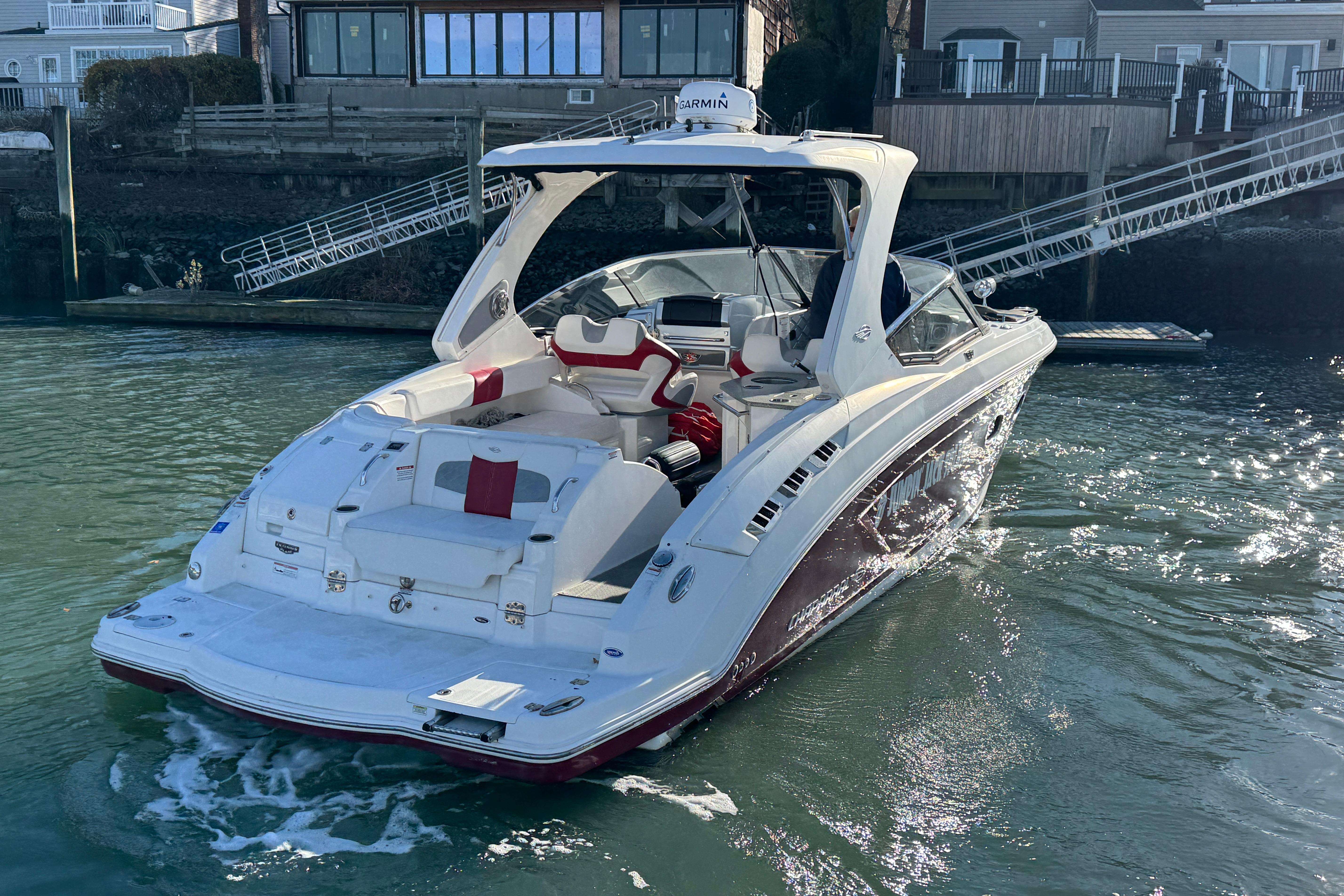 2012 Chaparral 327 SSX boat on water near dock, rear view.