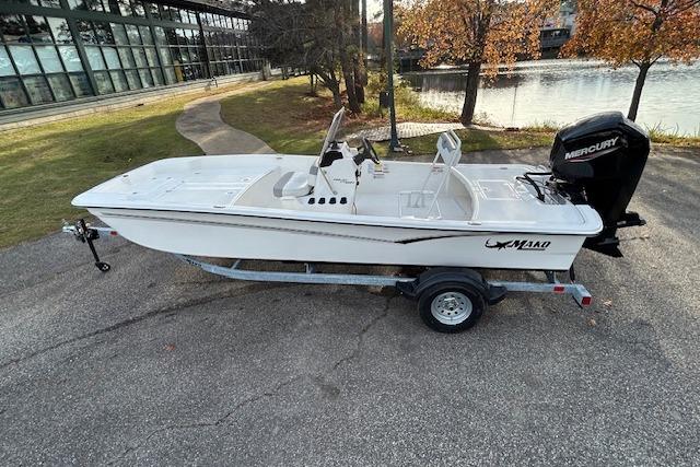 2025 Mako Pro Skiff 17 CC boat on trailer, parked near a lake.