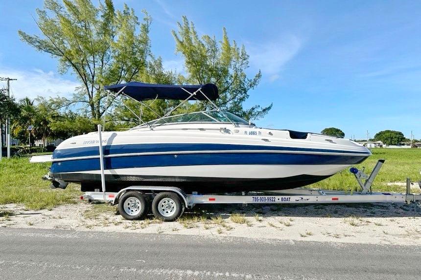 2005 Four Winns 264 Funship boat on trailer, parked outdoors, sunny day.