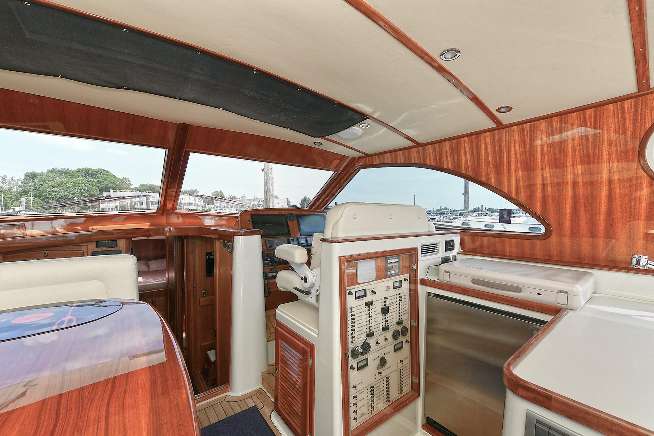 Luxurious 2005 San Juan Downeast Express yacht interior with elegant wood finish and modern controls.