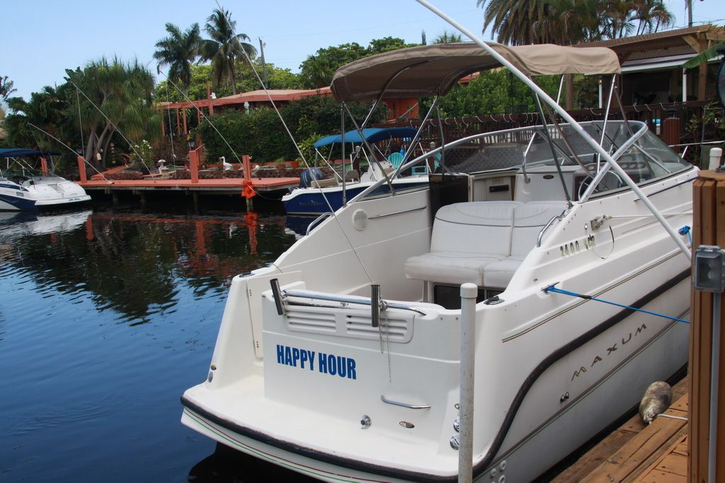 1999 Maxum 2400 Mercruiser boat docked in tropical setting.