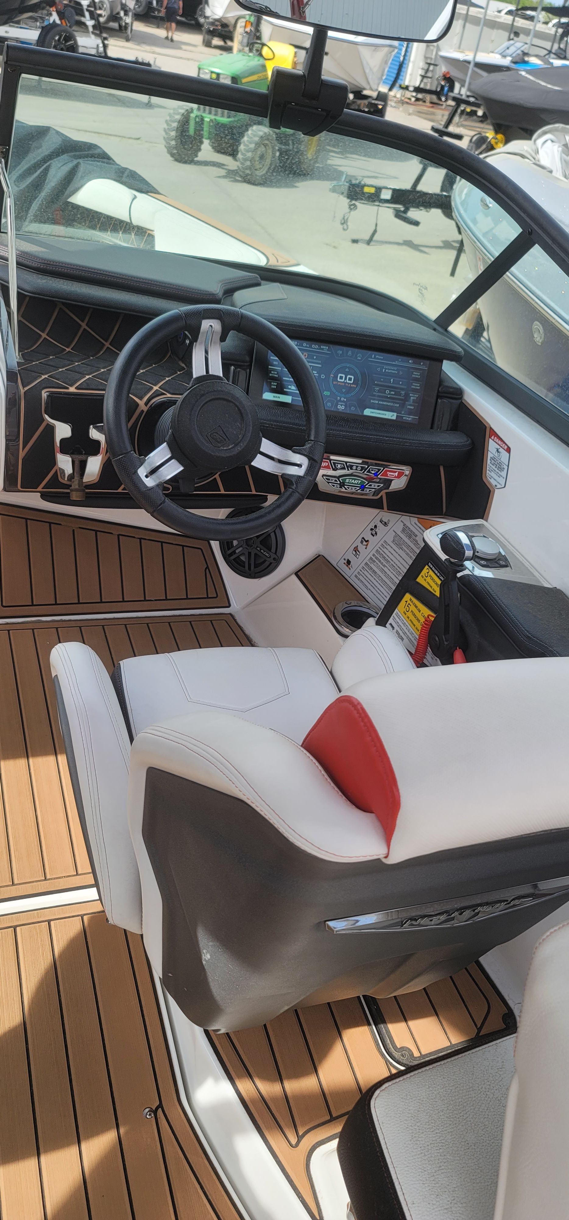 The image shows the cockpit of a 2019 Nautique Super Air Nautique GS22 with a modern steering wheel and digital display.