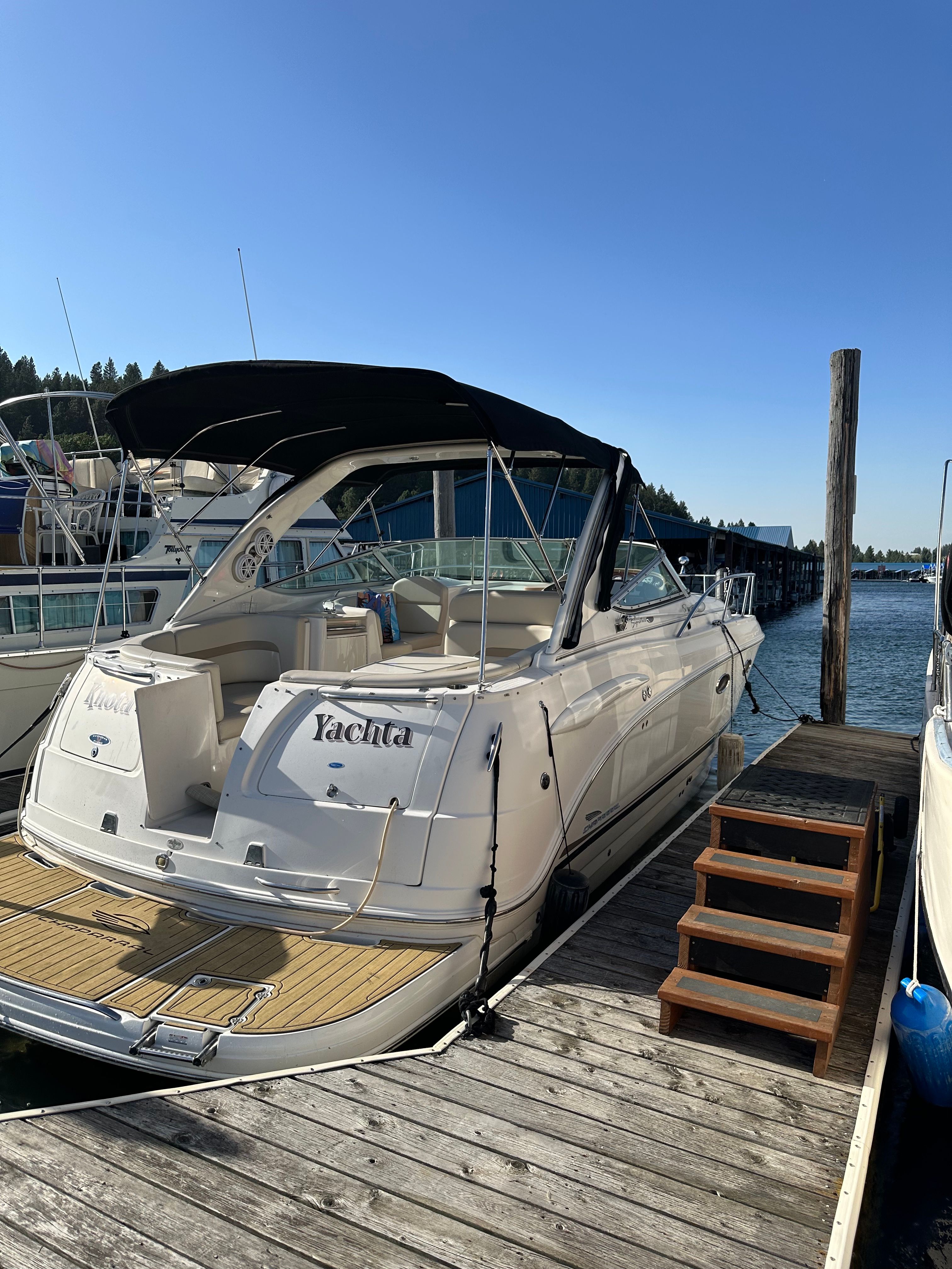 A white 2004 Chaparral Signature 330 boat docked on a sunny day.
