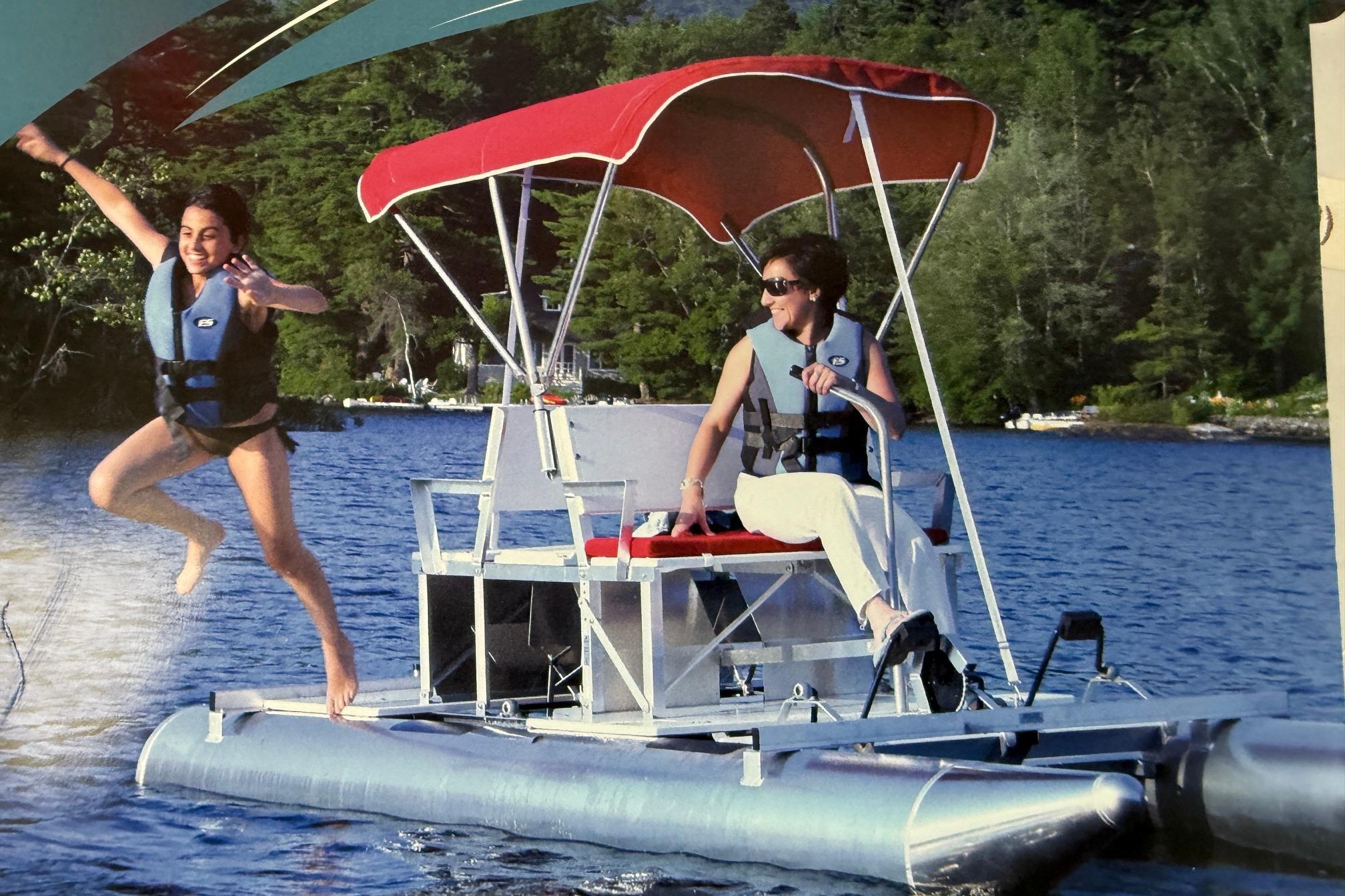 Two people enjoying a ride on a 2026 Aqua Cycle 2 pontoon boat.