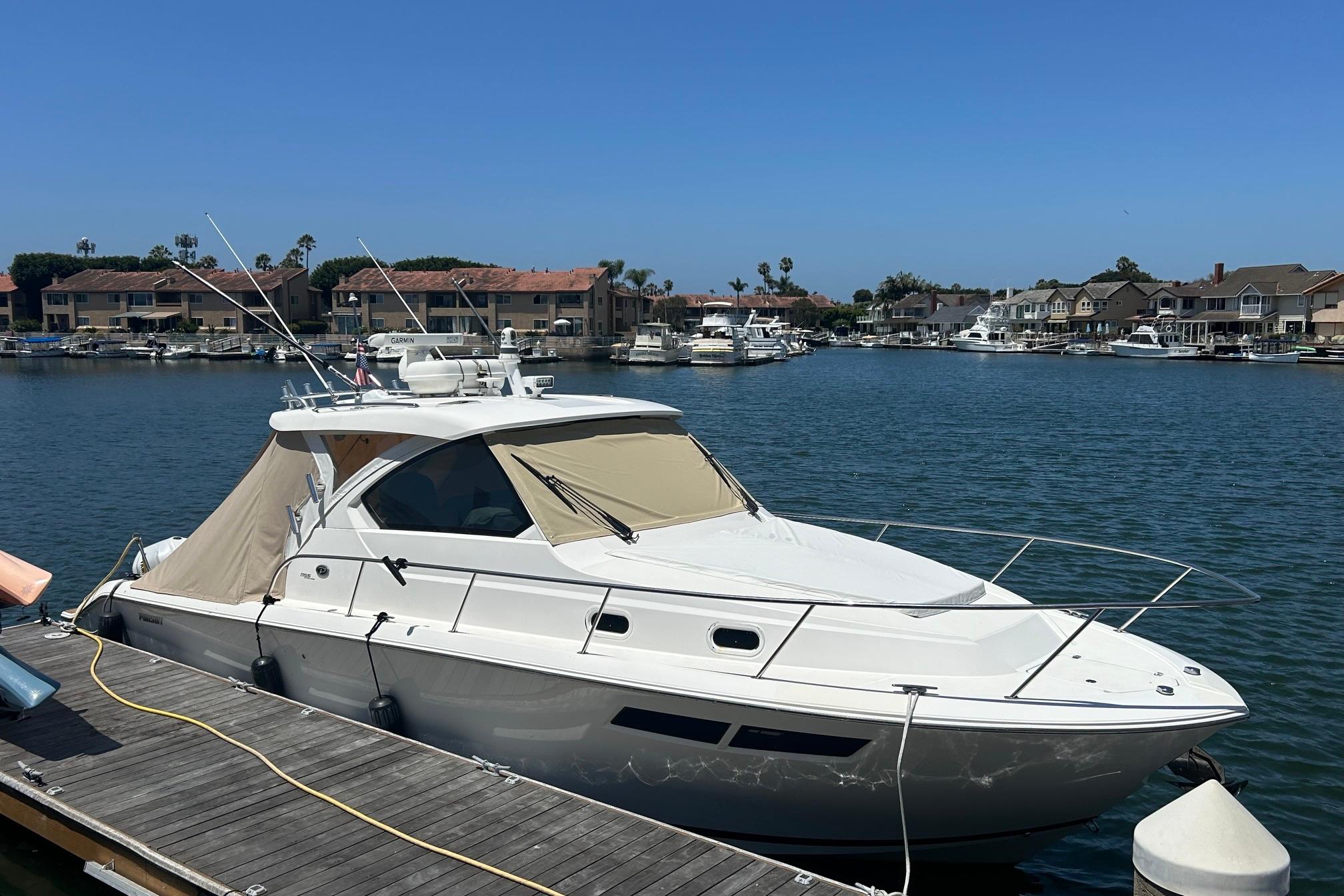 2019 Pursuit OS 355 Offshore boat docked in a scenic marina setting.