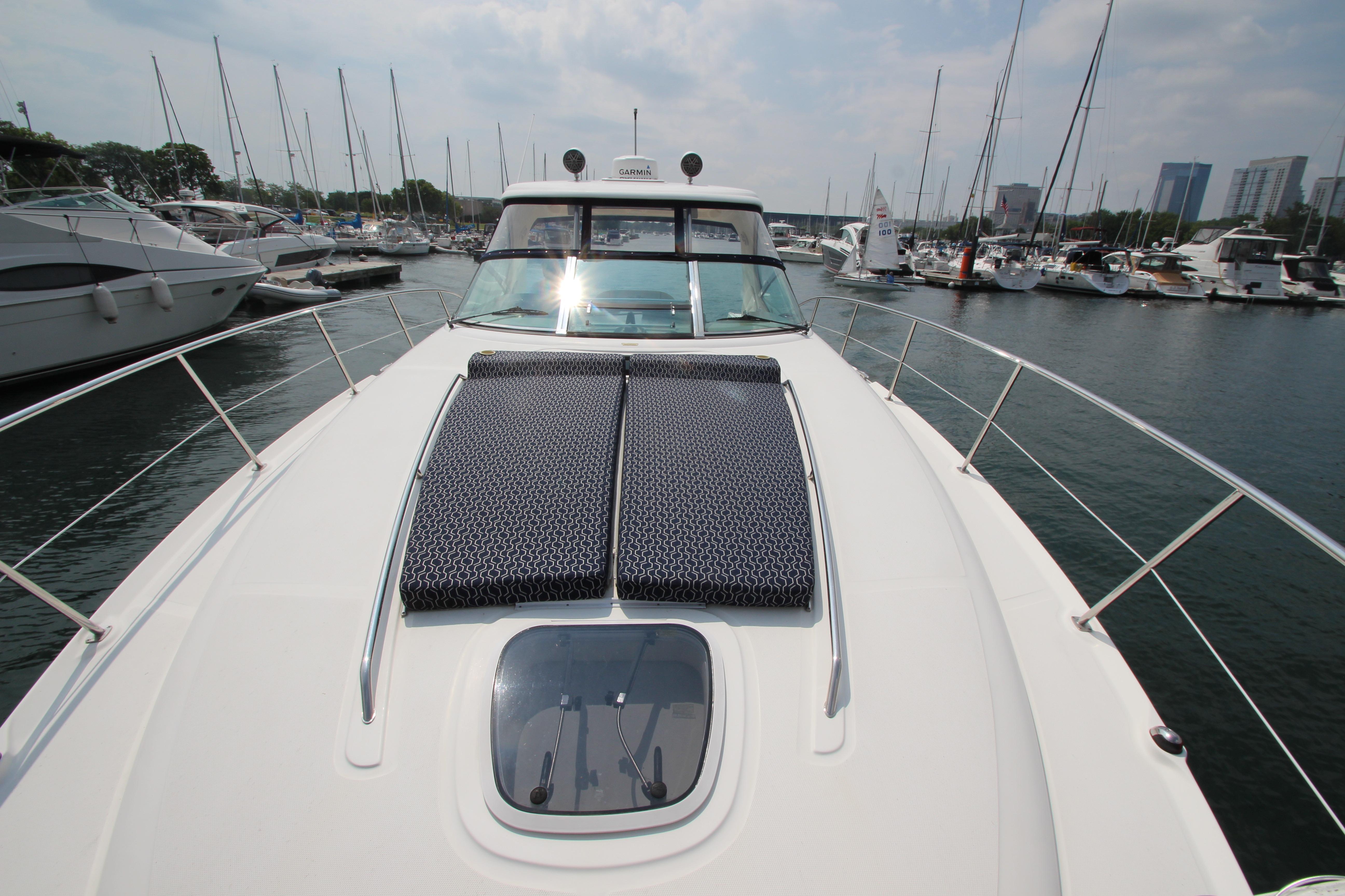 2004 Sea Ray 40 Sundancer yacht docked in marina, featuring sun pads and sleek design.
