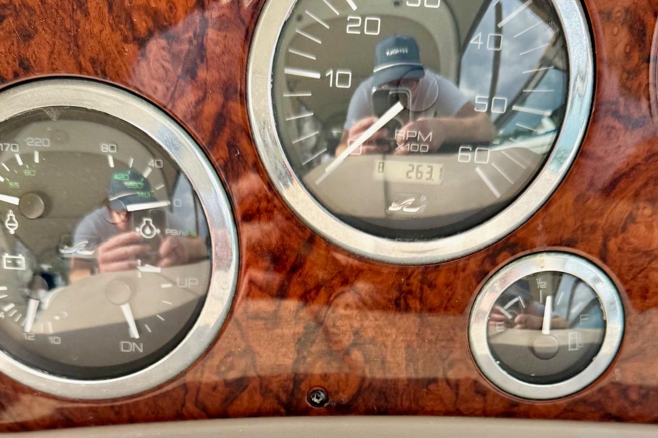 Dashboard of a 2003 Sea Ray 300 Sundancer boat with wood grain finish and gauges.