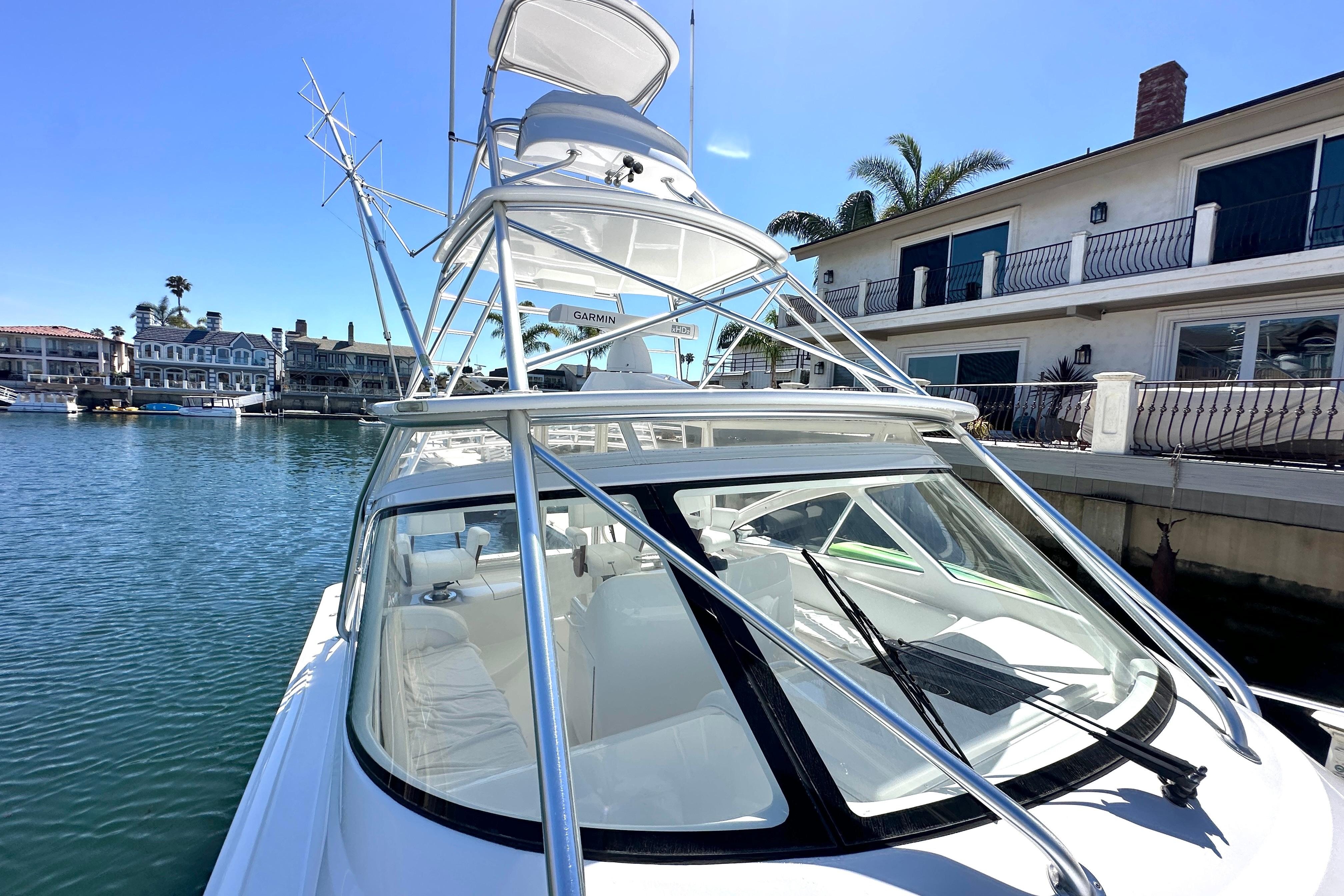 2012 Viking 42 Open yacht docked near waterfront homes.