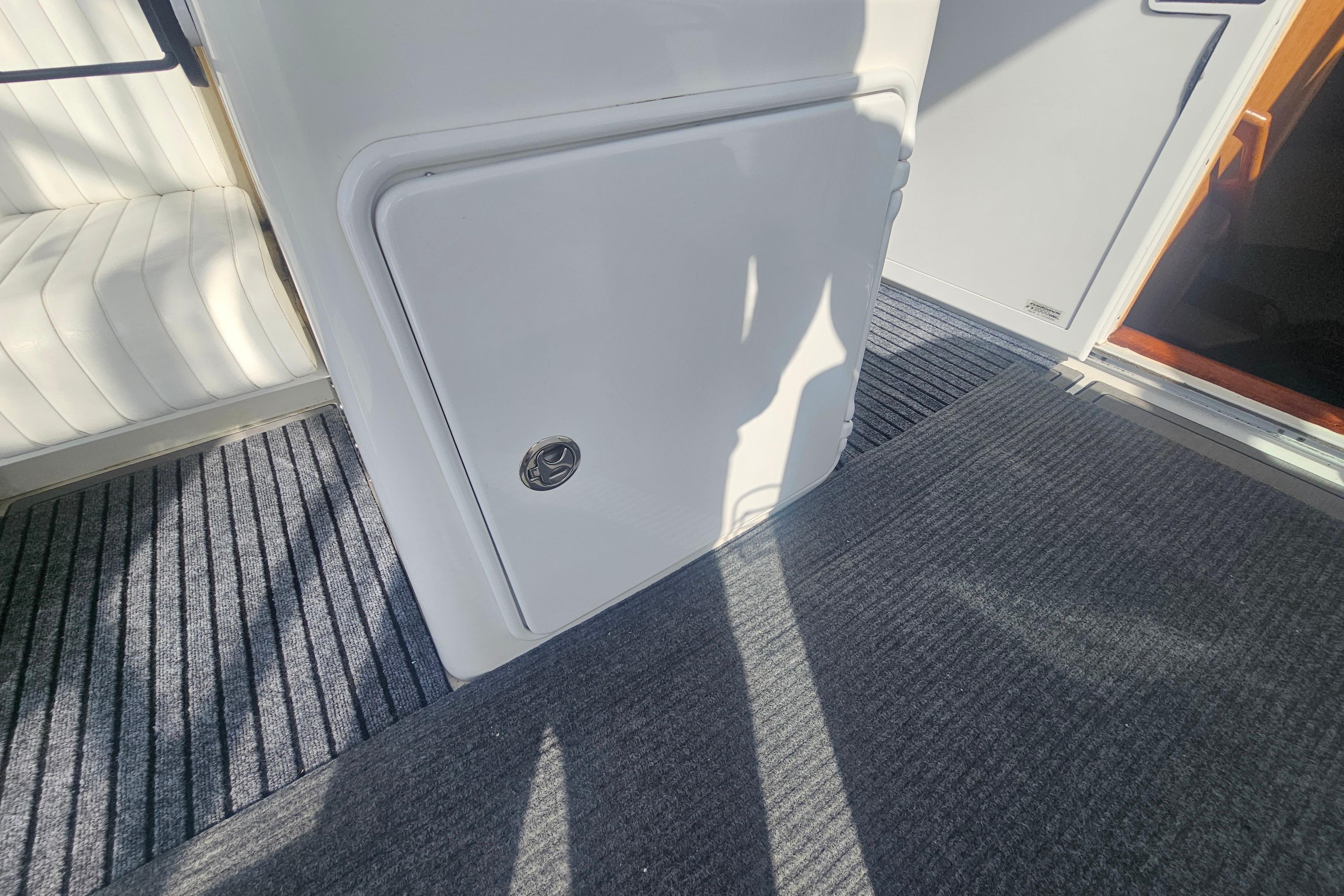 2003 Topaz 32 Express boat interior with carpeted flooring and storage compartment.