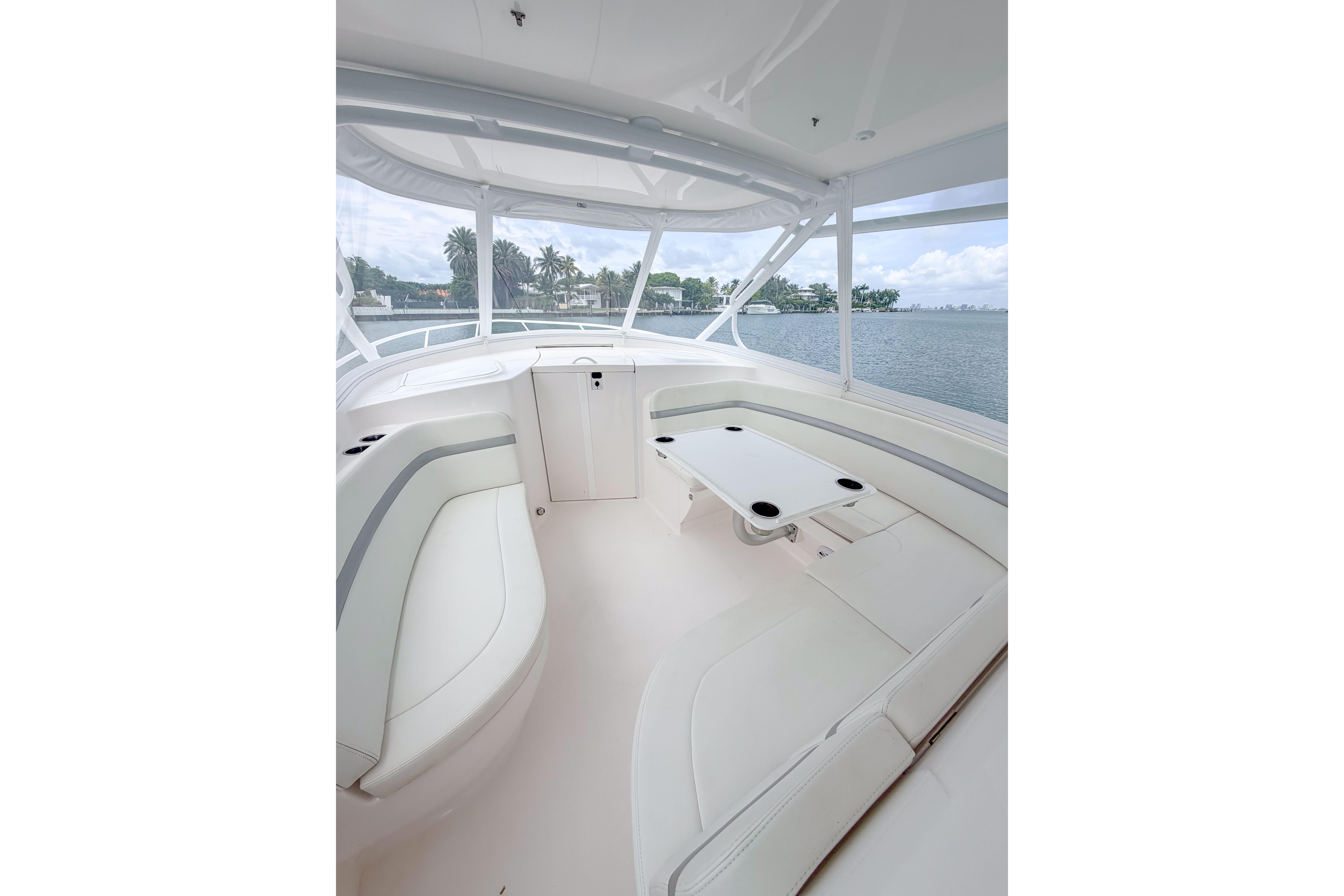 Luxurious interior of 2021 Intrepid 409 Valor boat with white seating and table.