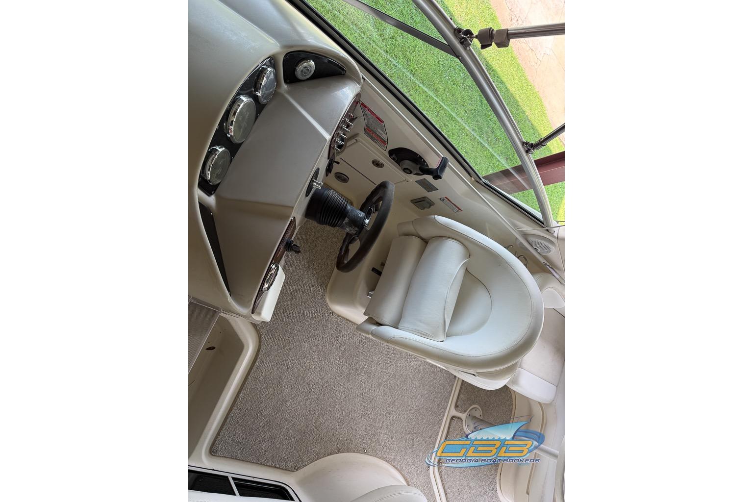 2006 Sea Ray Sundancer 260 helm with steering wheel and gauges, featuring a comfortable captain's chair.