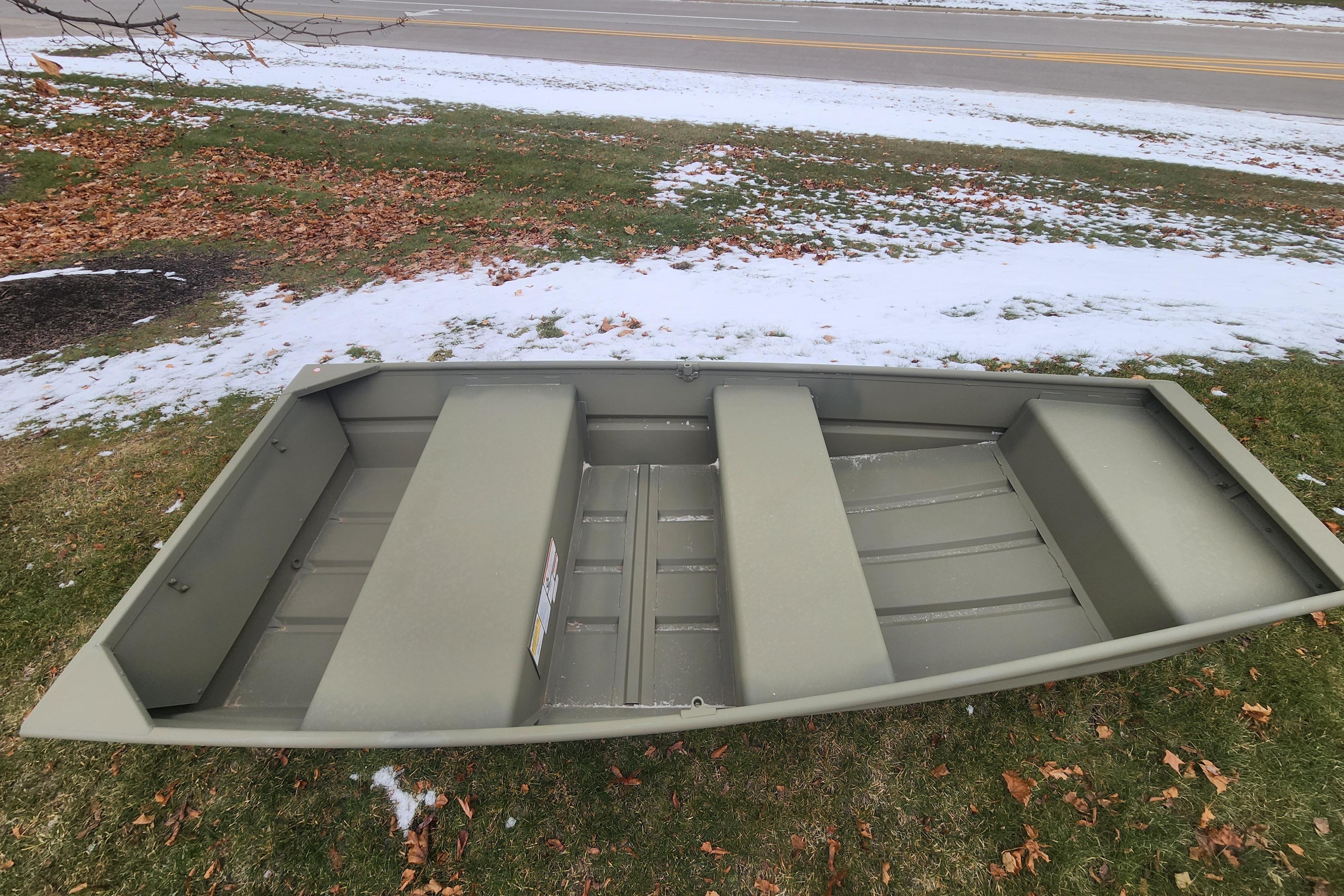 2026 Tracker Grizzly 10 Jon boat on snowy grass, showcasing its sturdy design.