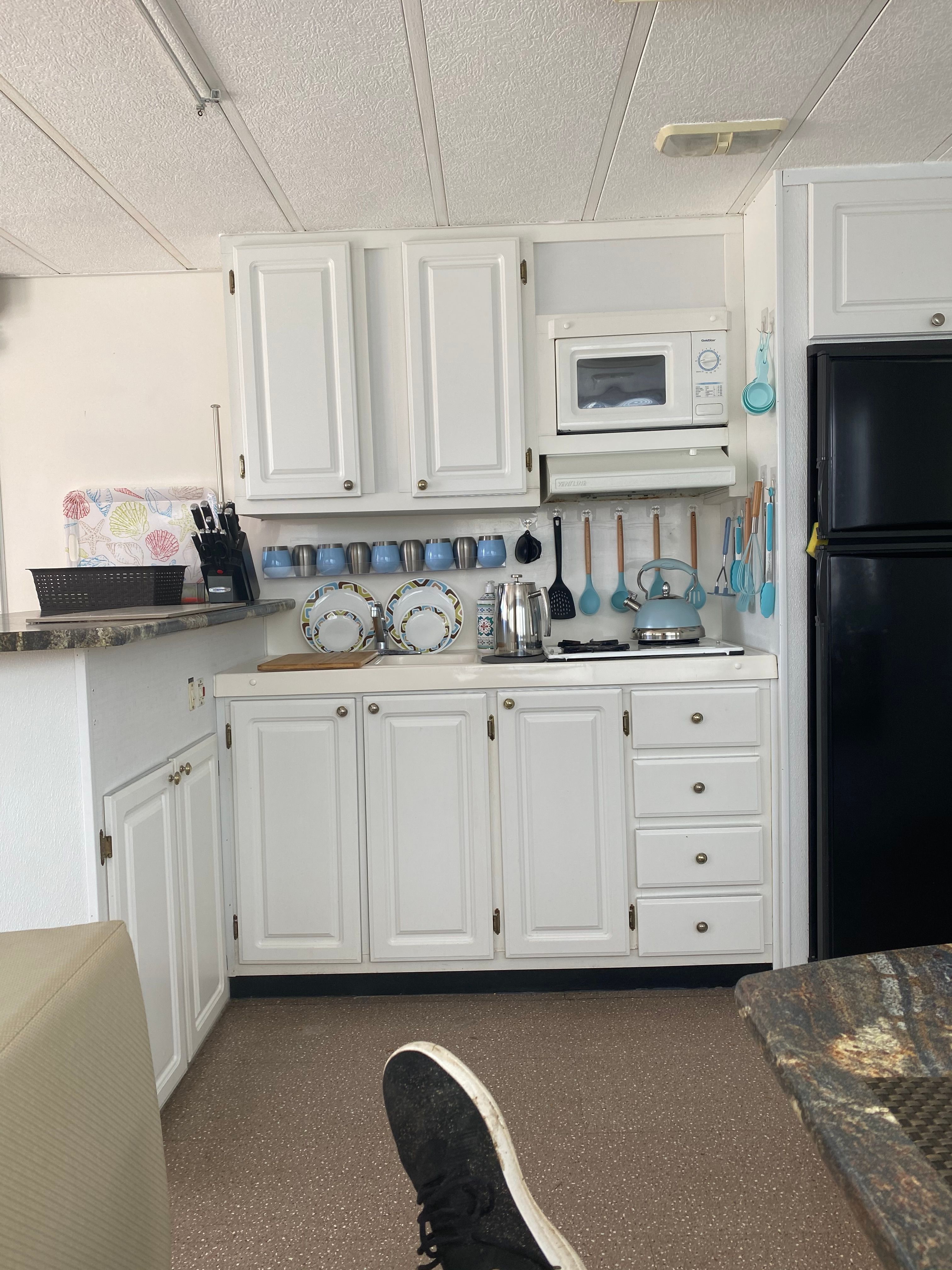 Interior of a 42 ft Catamaran Cruiser kitchen with white cabinets and appliances.